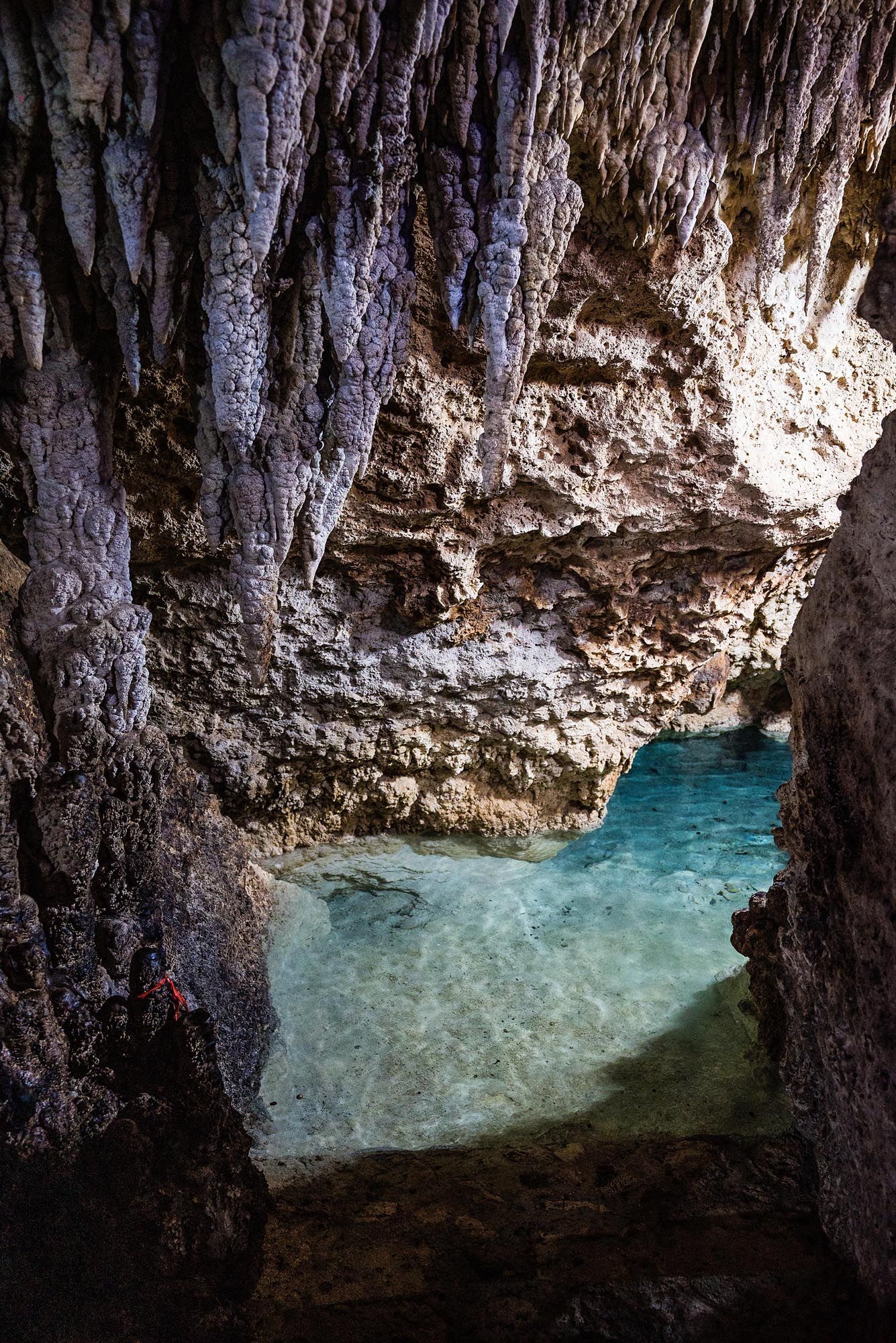 Sequence of photos showing a natural cave formation with turquoise blue water and rugged limestone walls lit from above.