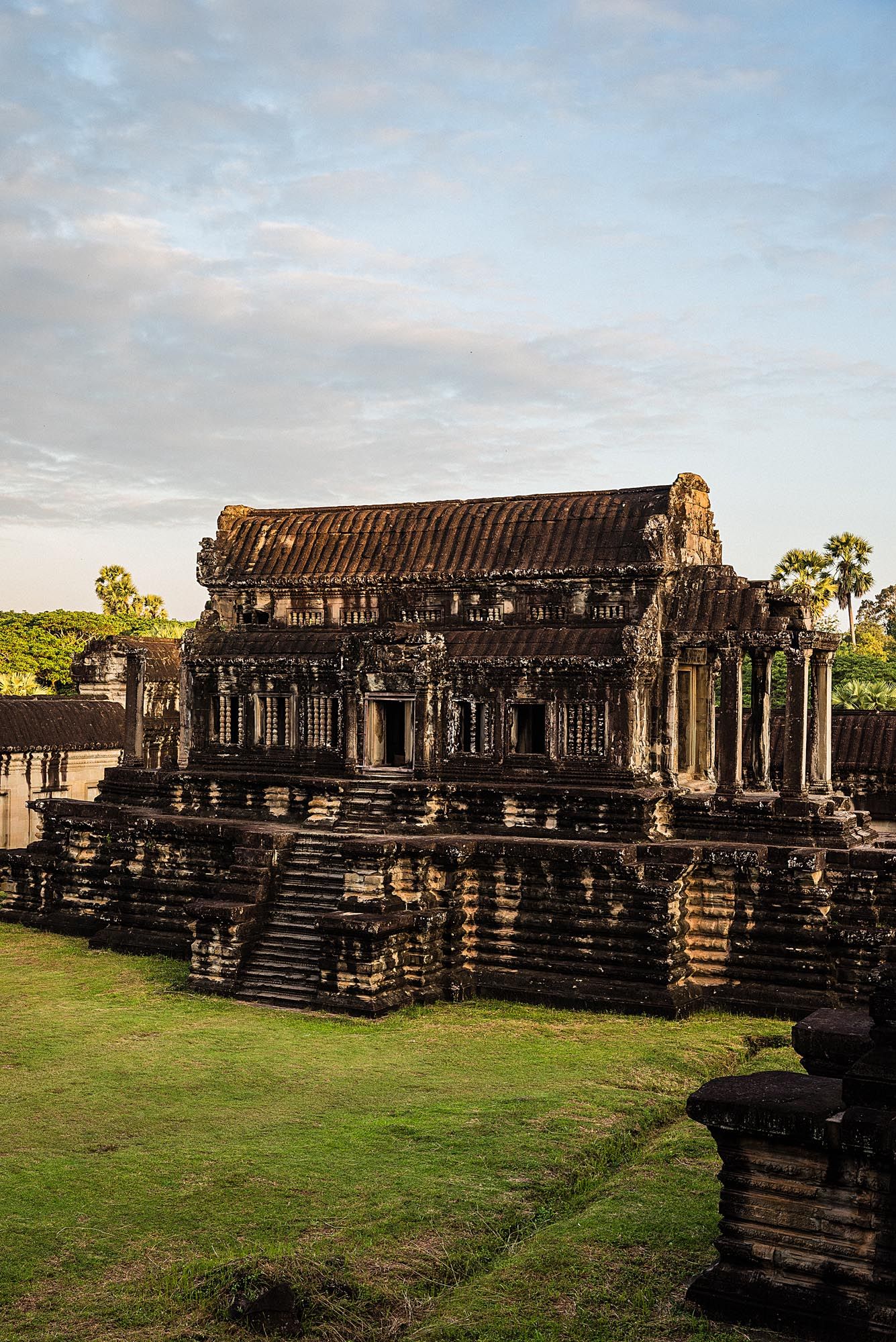 Ancient stone temple ruins of Angkor Wat in Cambodia showing detailed architectural structures at sunset.