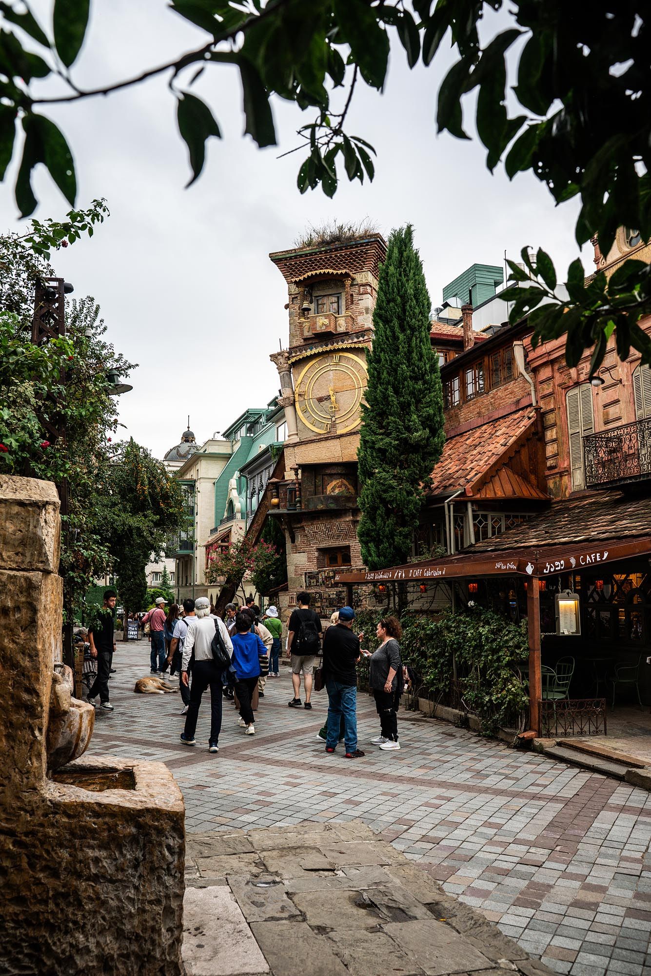A charming cobblestone street lined with rustic buildings and shops in a European-style theme park setting.