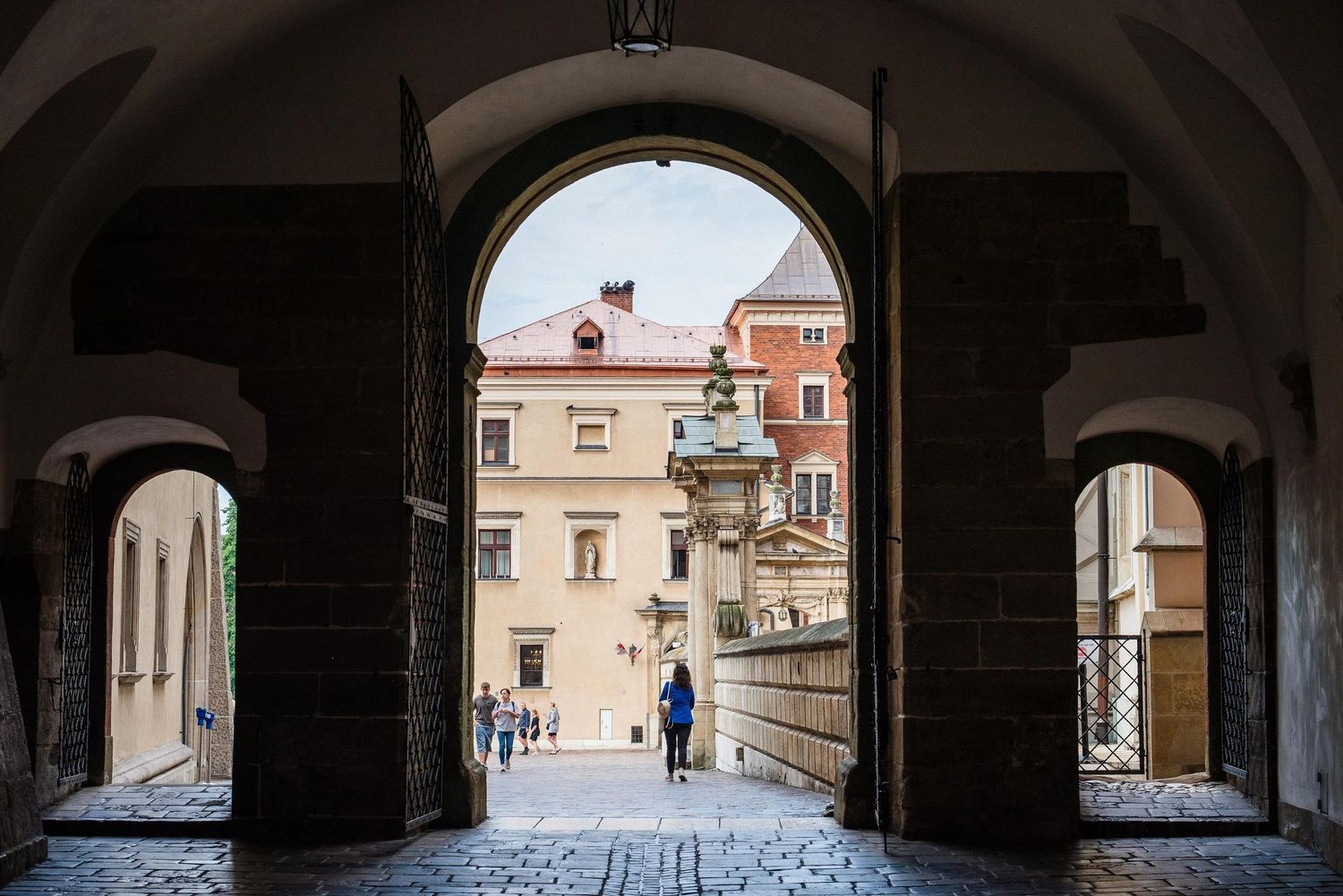 Looking through a series of connected archways in an Italian town, showing classic architecture and stone pathways.