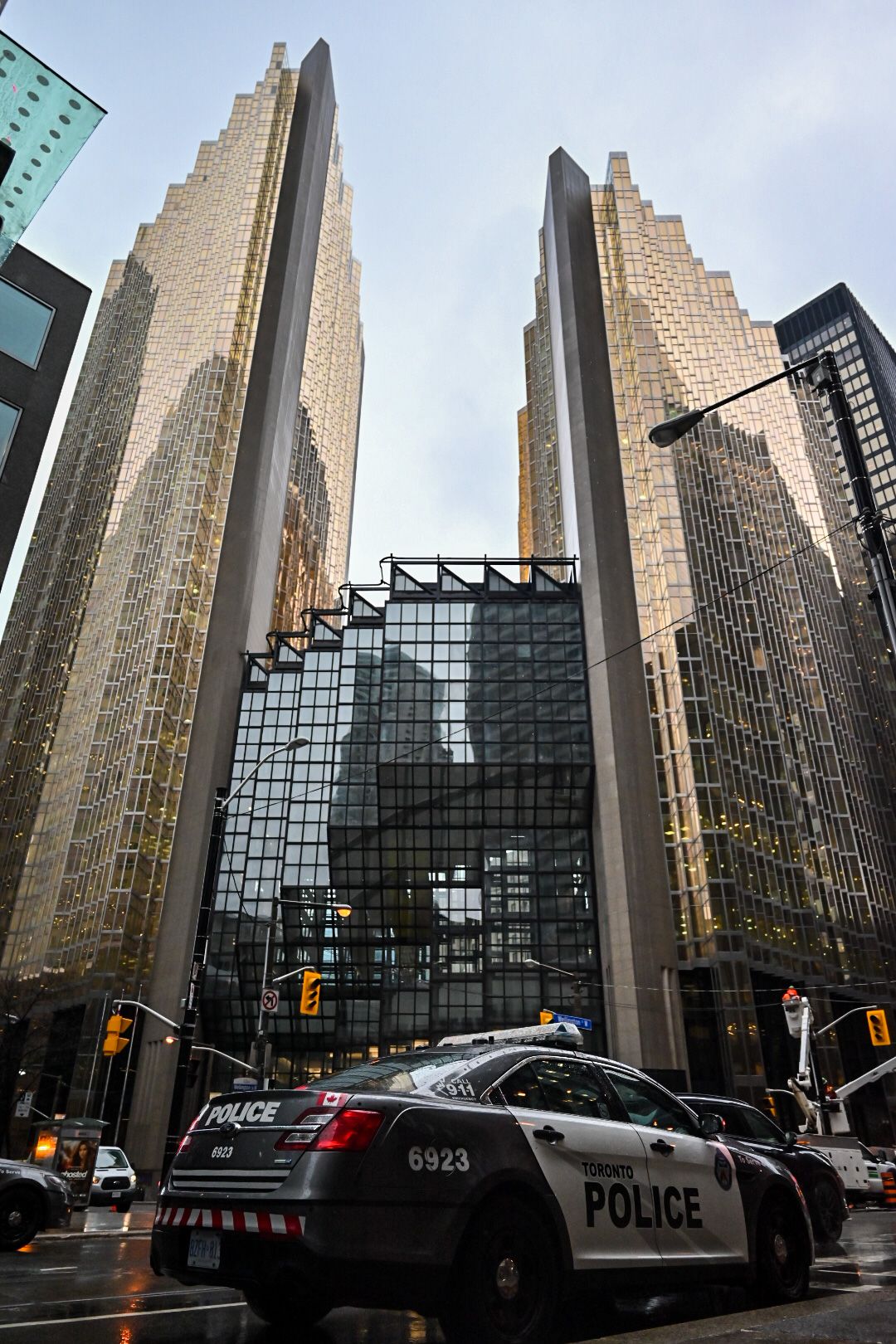 Modern glass and stone skyscrapers with police car in Toronto financial district.