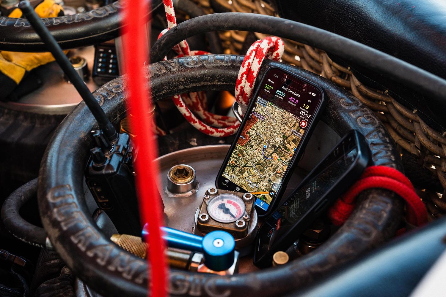 Close-up view of a car engine bay showing red and black wiring components and mechanical parts.