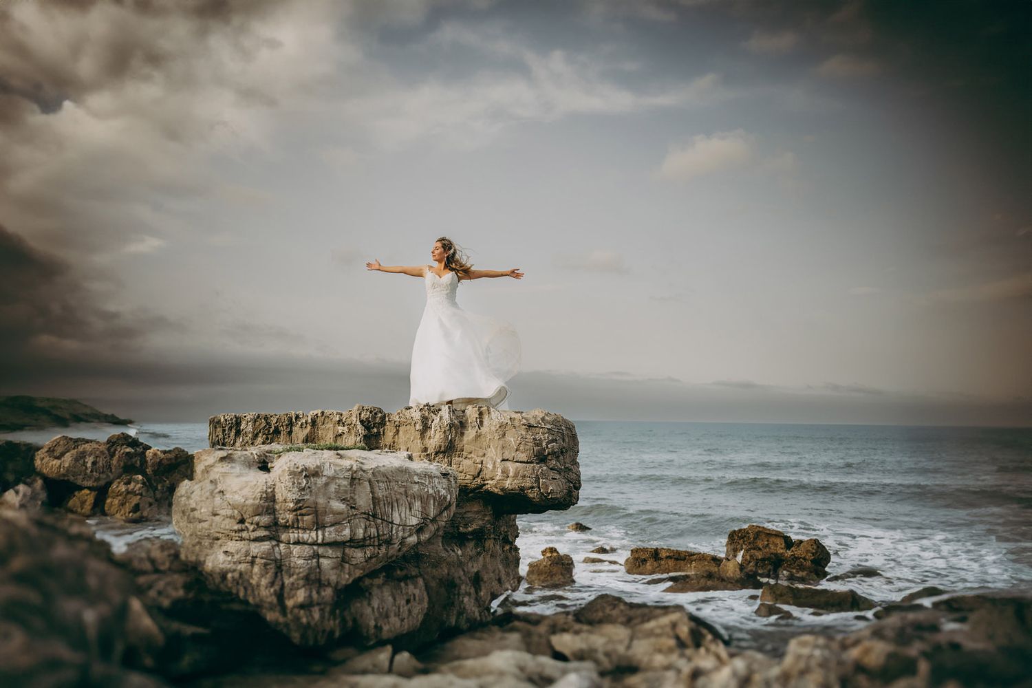 Postboda en la costa de Asturias. Novia sobre una roca frente al mar, fotografía natural y emocional.