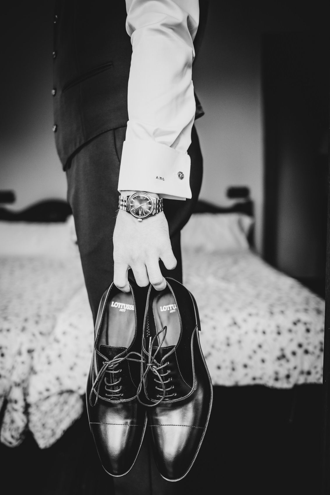 Novio sujetando sus zapatos y con el reloj puesto durante los preparativos de boda en Asturias