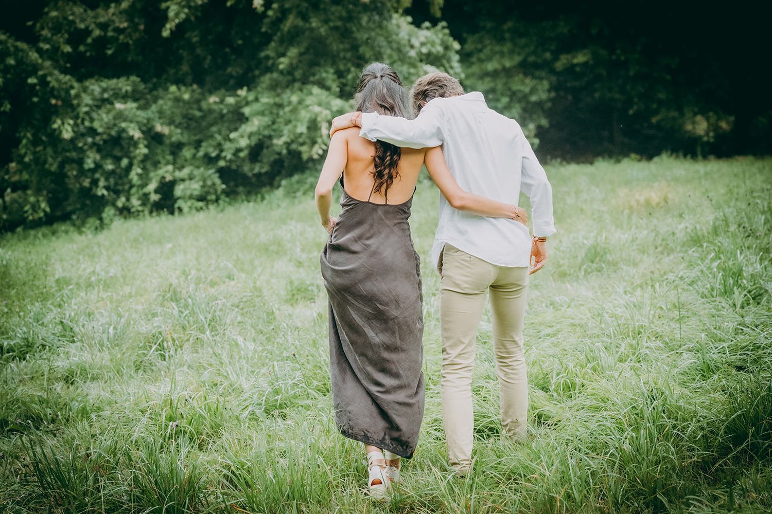 Pareja caminando de espaldas durante una sesión de preboda en Asturias, en un entorno tranquilo