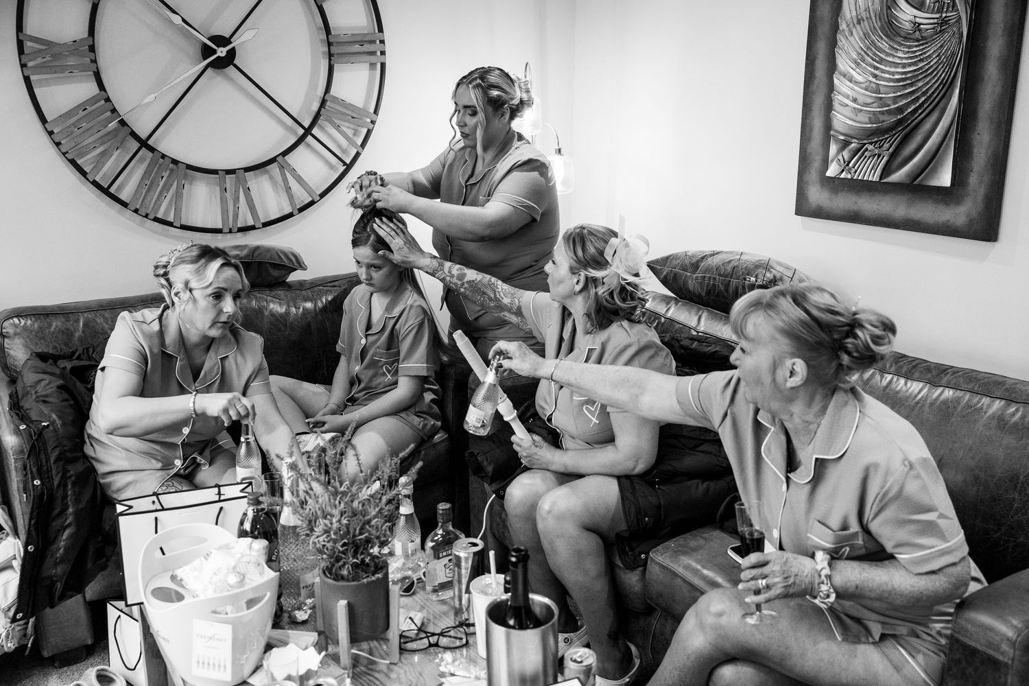 A black and white photo collage shows people gathered on couches in a living room setting with large clocks on the wall.