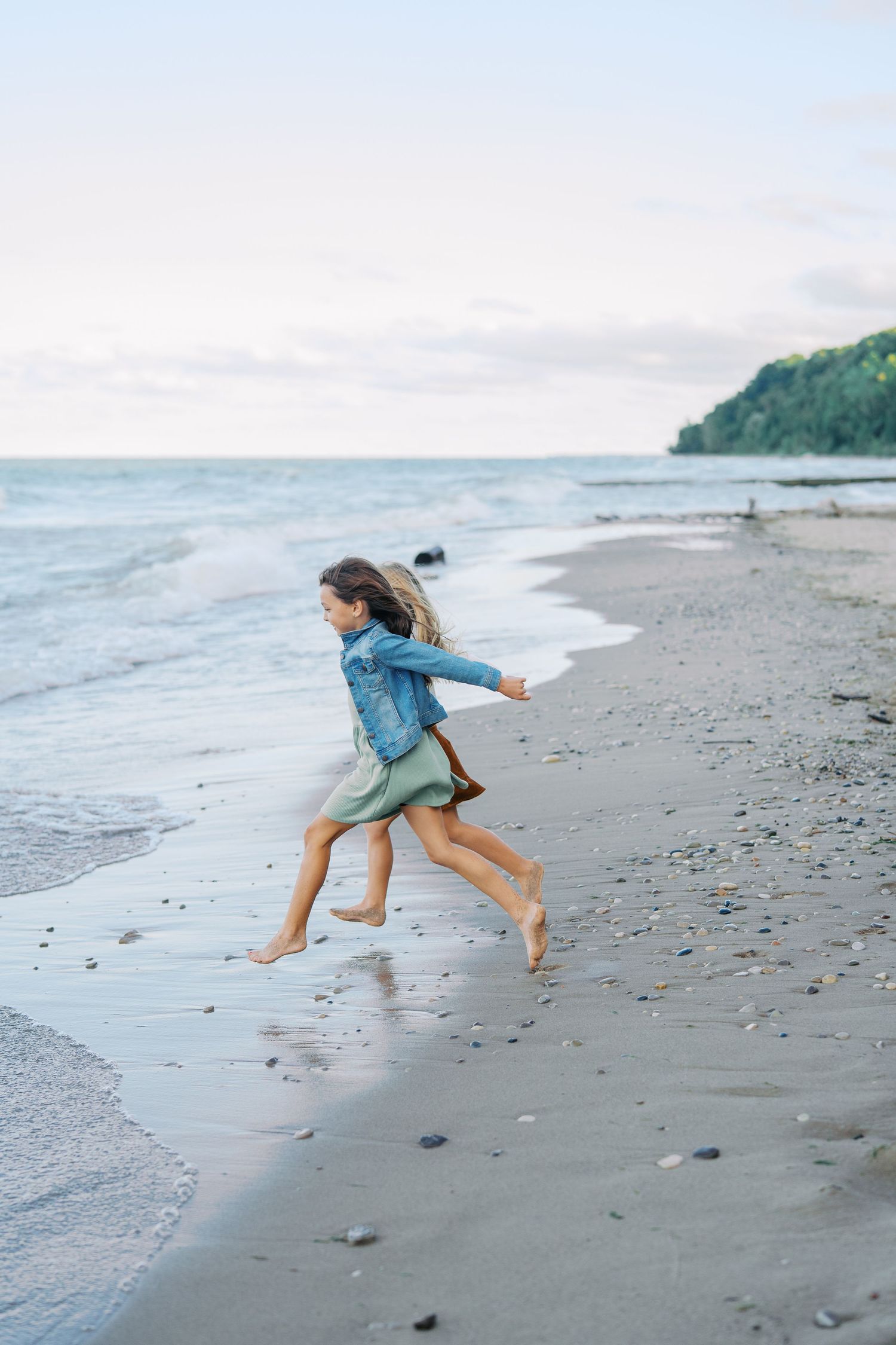 Dynamic sequence of someone playing and jumping in the waves at a scenic beach.
