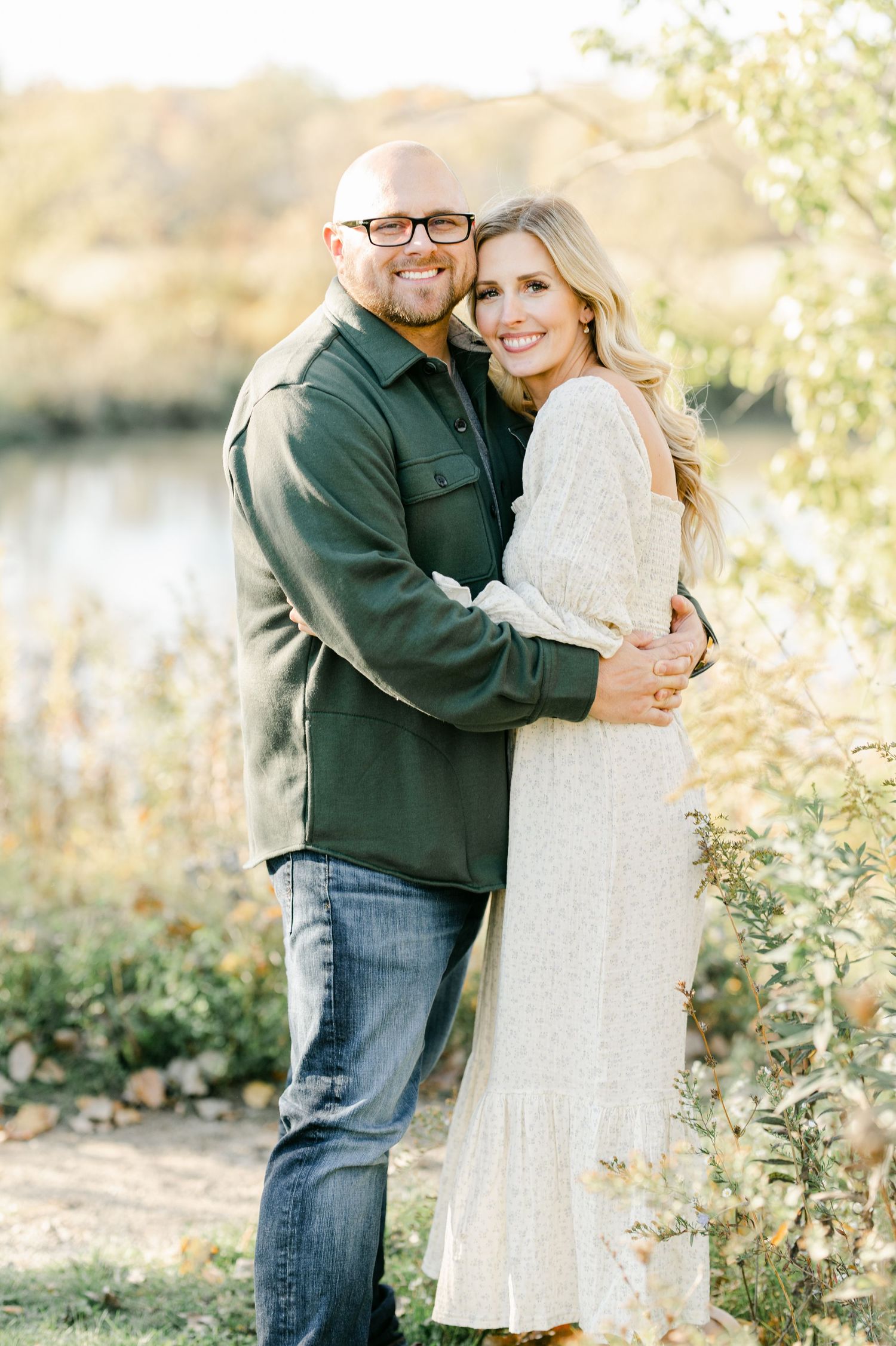 A couple embraces during an autumn photoshoot in natural lighting.