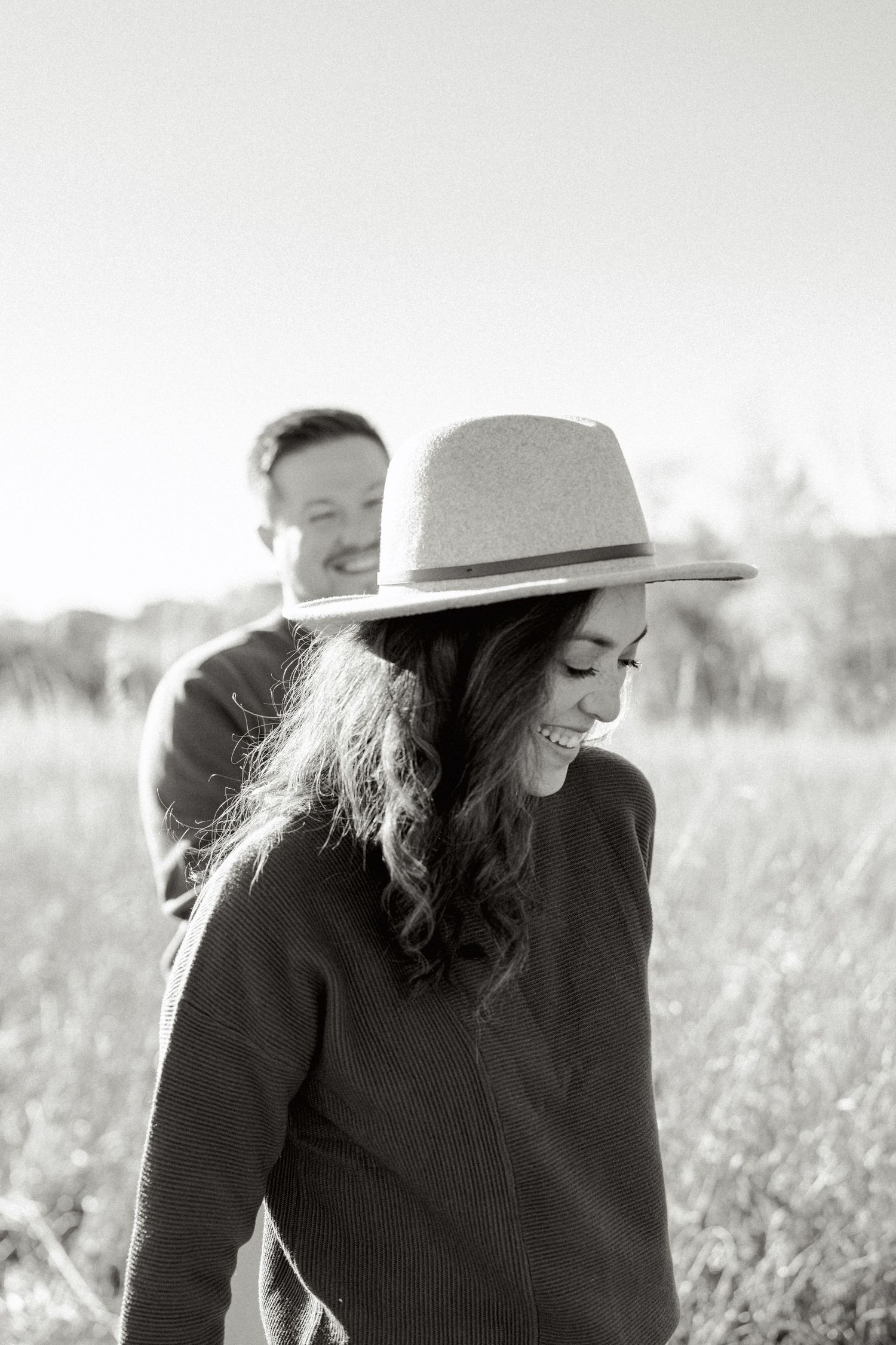 A couple enjoys a peaceful moment together in a sunlit meadow.