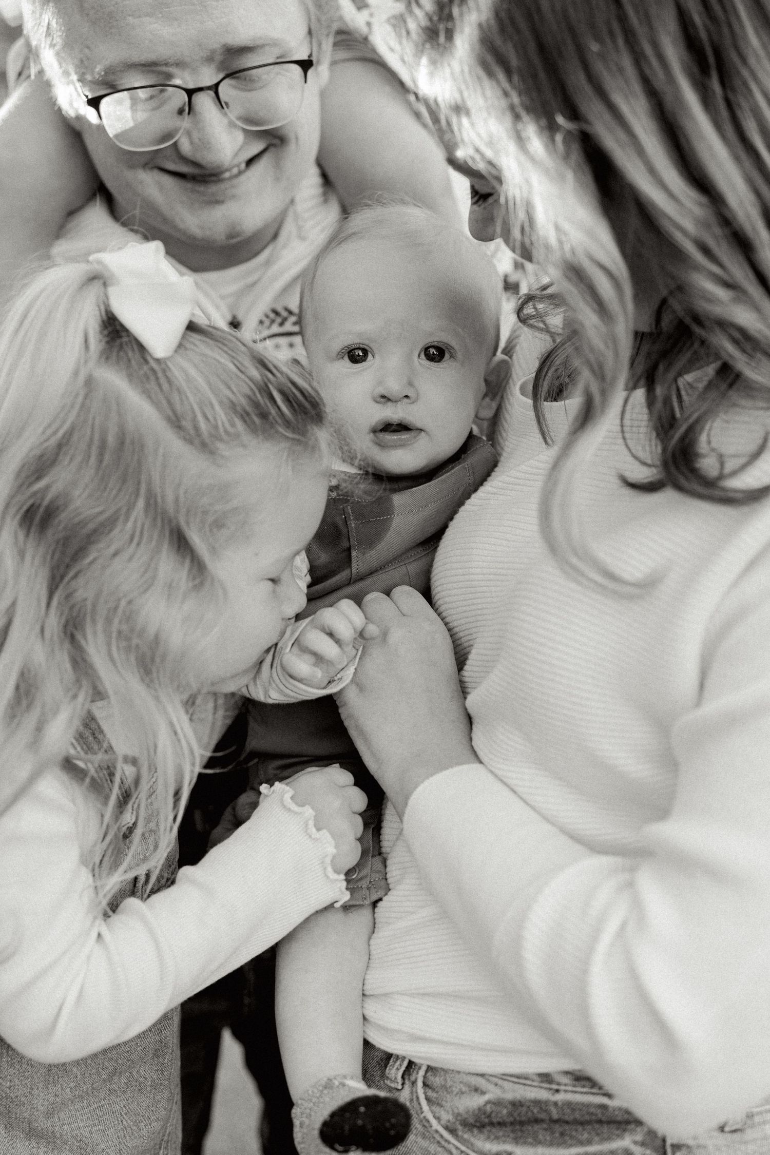 Intimate black and white family portrait showing tender moment of connection.