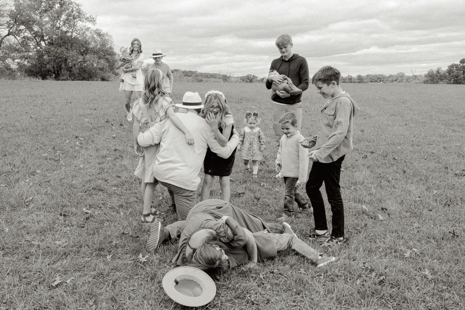 Candid family moments captured in black and white on an open field.