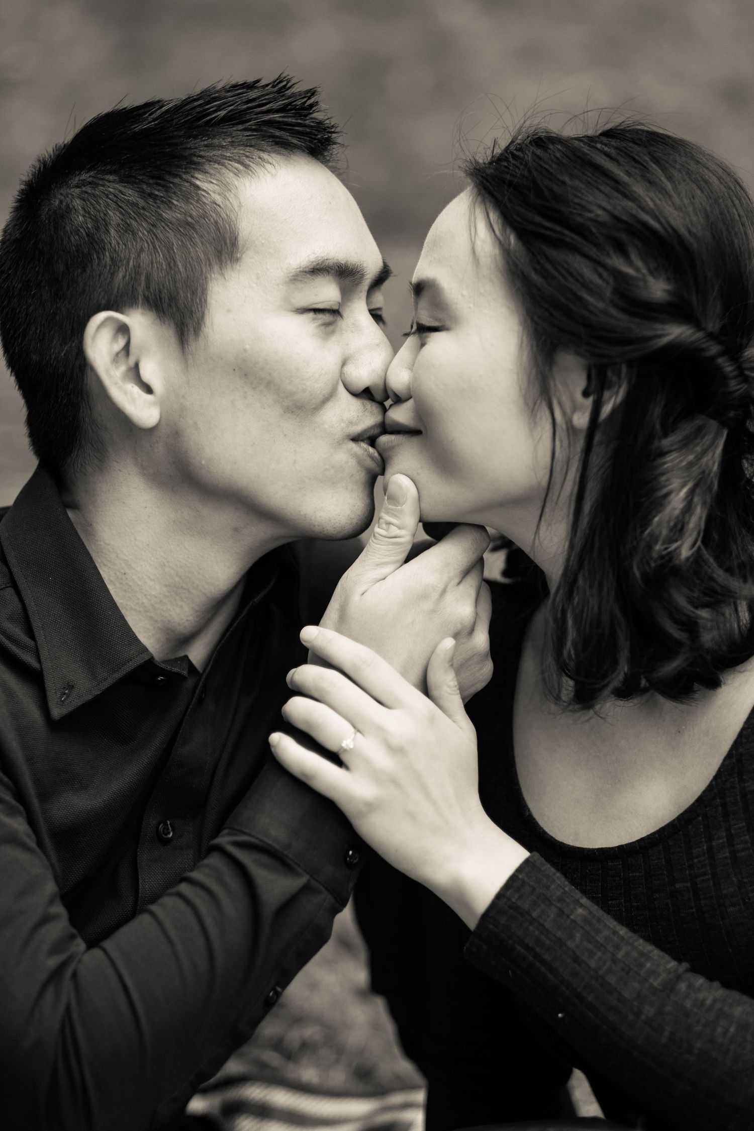 Black and white romantic portrait of a couple sharing a kiss while dressed in dark sweaters taken by Melbourne couples photographer.