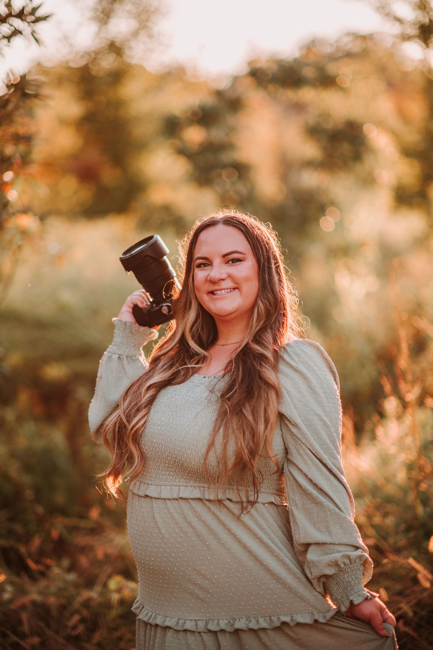 A warm golden-hour portrait session in nature with soft lighting and autumn colors in the background.