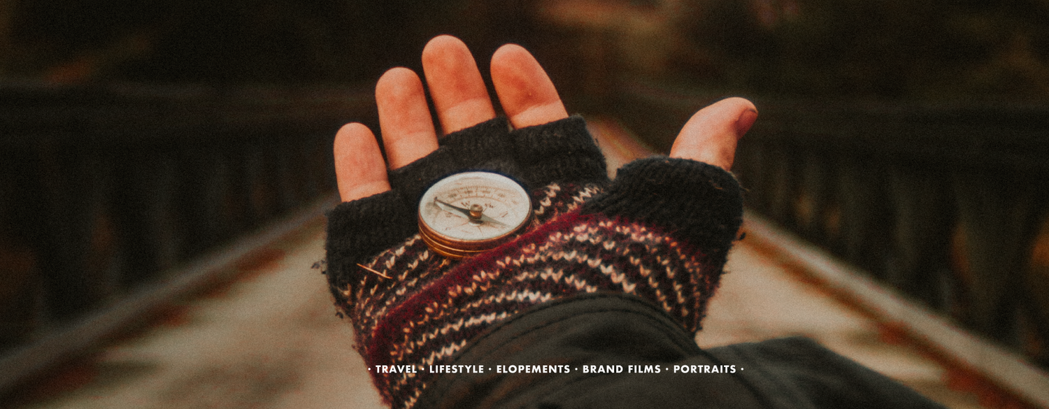 A hand wearing fingerless gloves holds a compass outdoors, with travel and lifestyle text overlay in Scotland