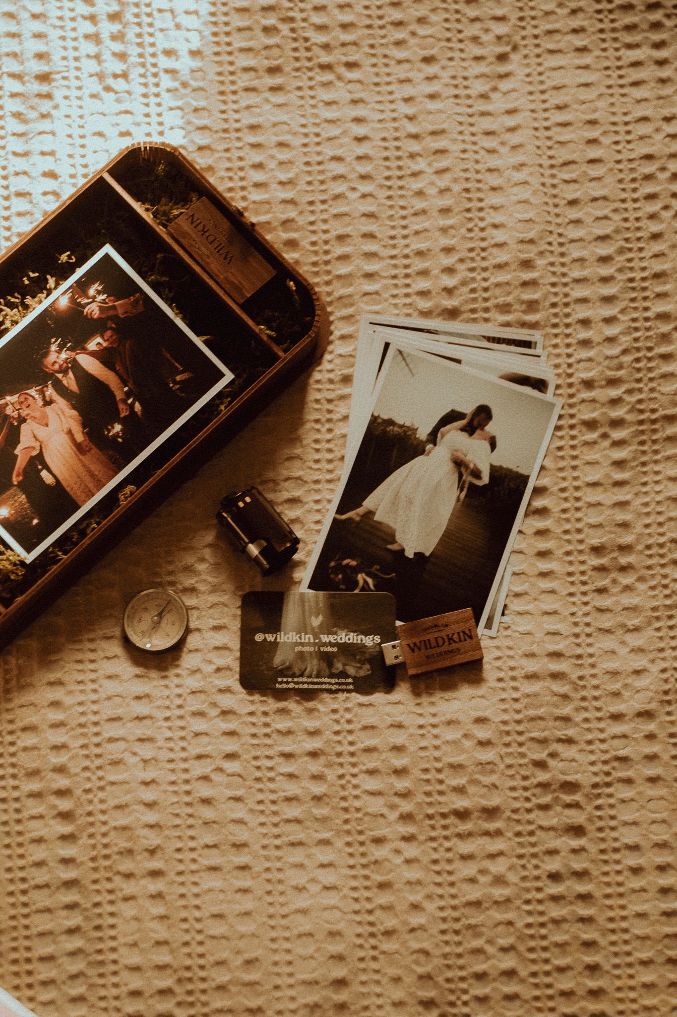 Scattered vintage photographs and film negatives arranged on a textured beige background in a nostalgic composition.