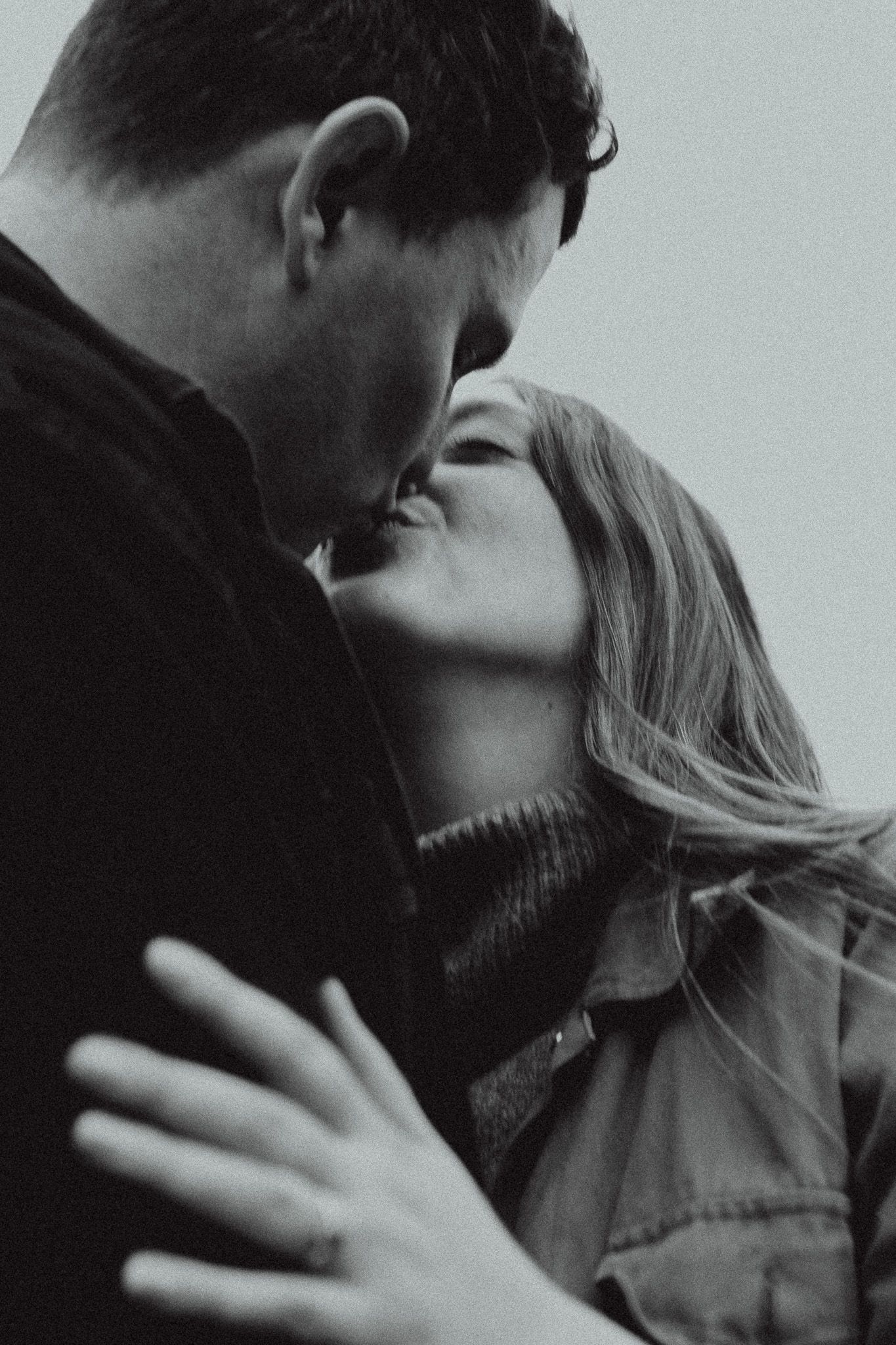 A romantic black and white photo sequence showing a couple embracing and sharing an intimate kiss.
