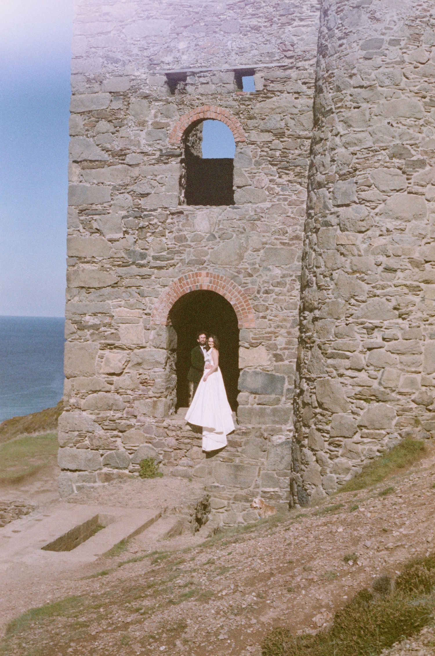 A sequence of five vintage photographs showing a stone castle doorway entrance against a coastal backdrop.