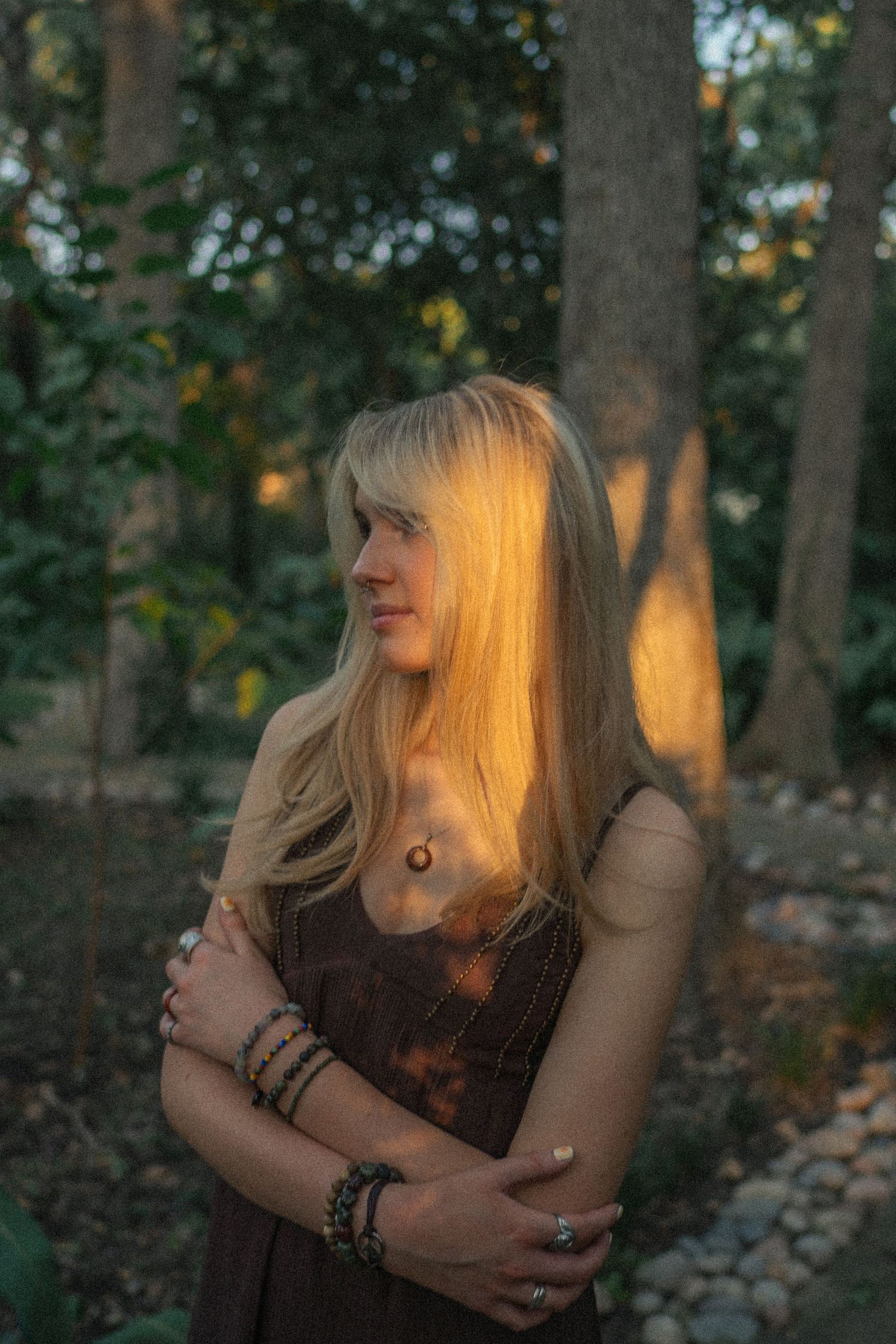 A portrait bathed in golden sunset light filtering through forest trees.