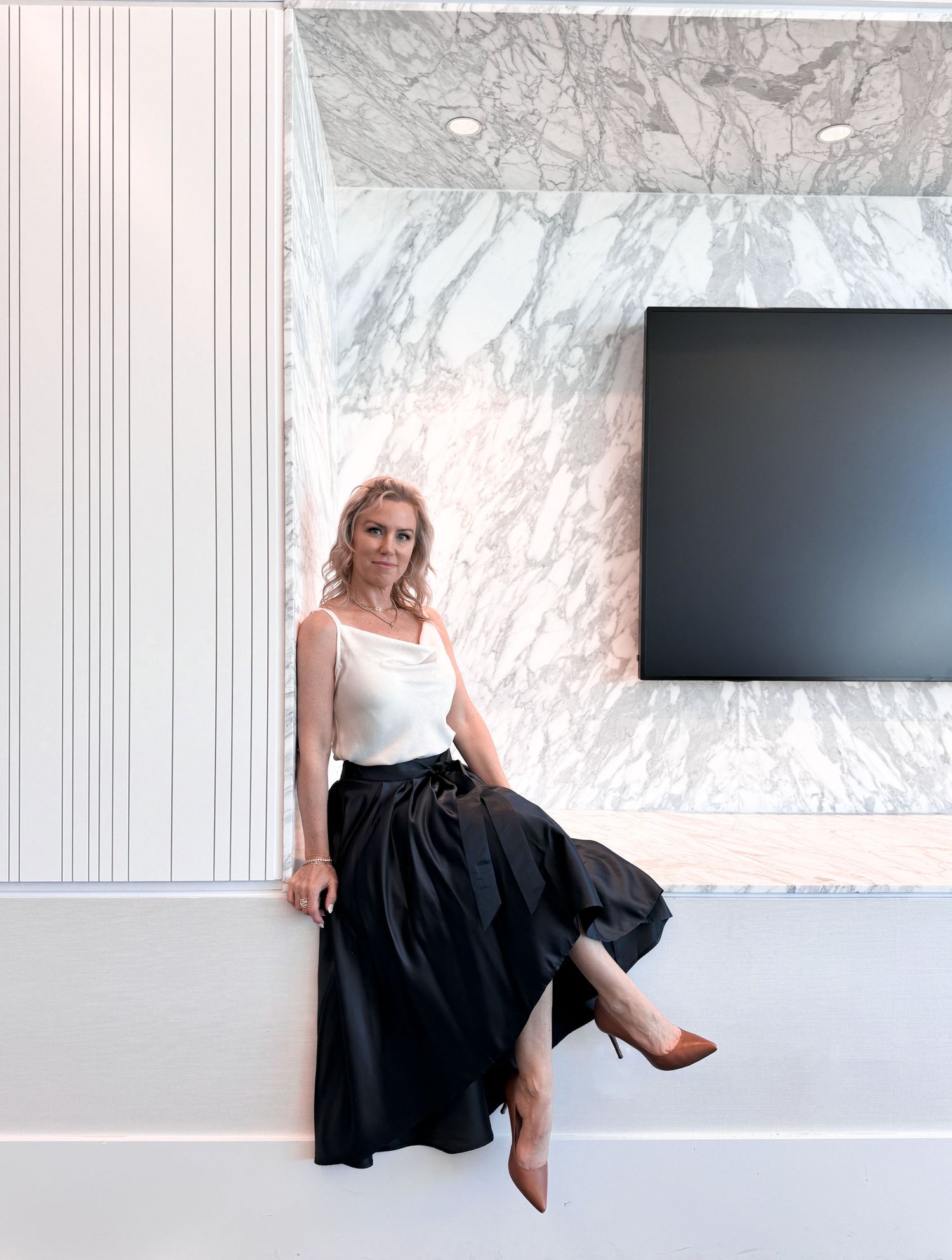 Modern interior design featuring marble walls and black skirt against minimalist decor.