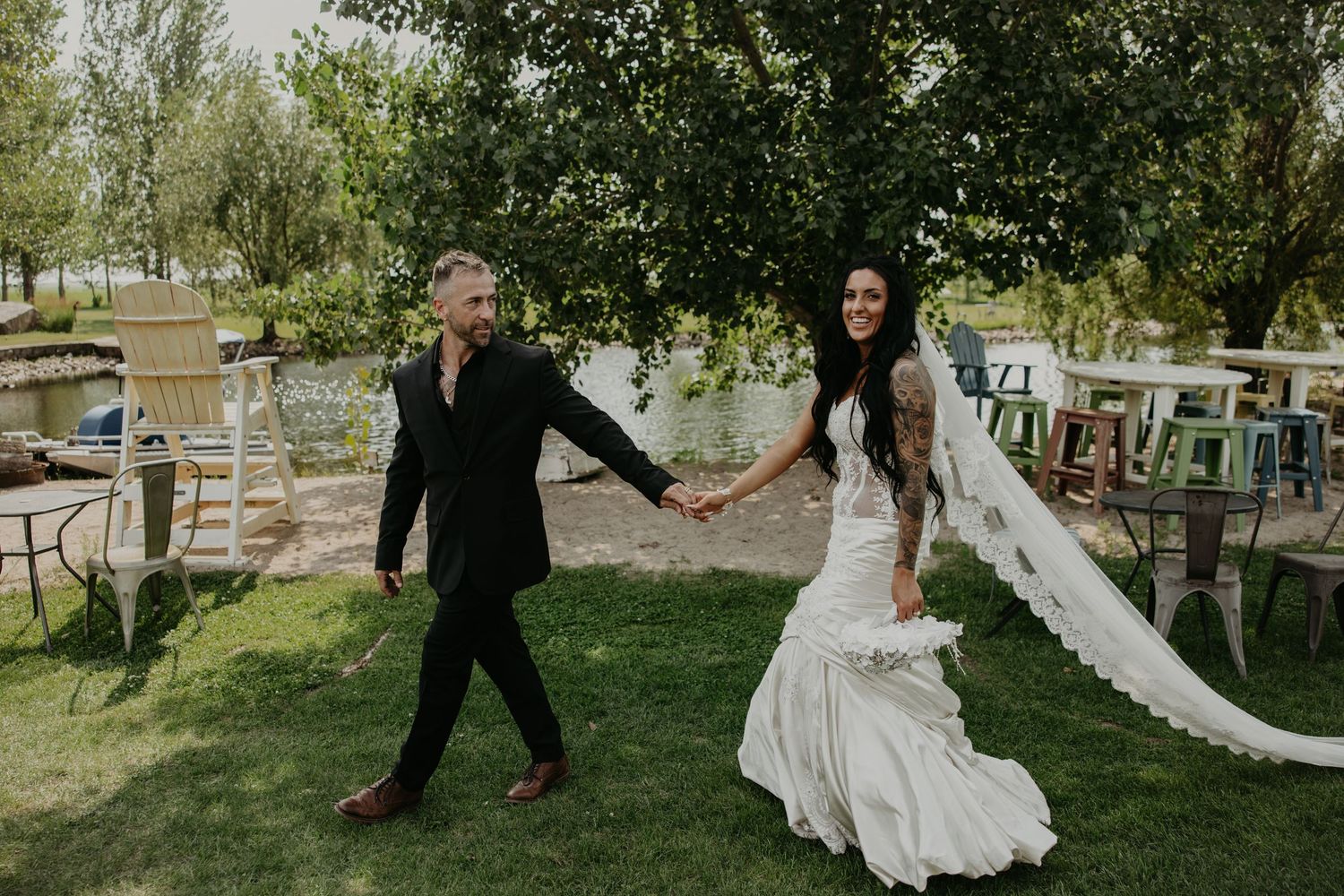 Wedding couple dancing and twirling in a garden setting with natural greenery.