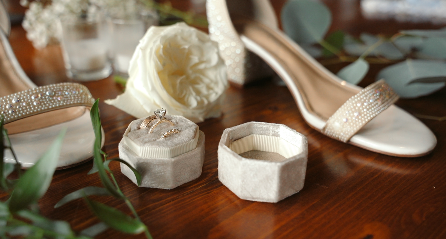 A close-up view of a rustic wedding table setting with white plates, floral arrangements and delicate details.