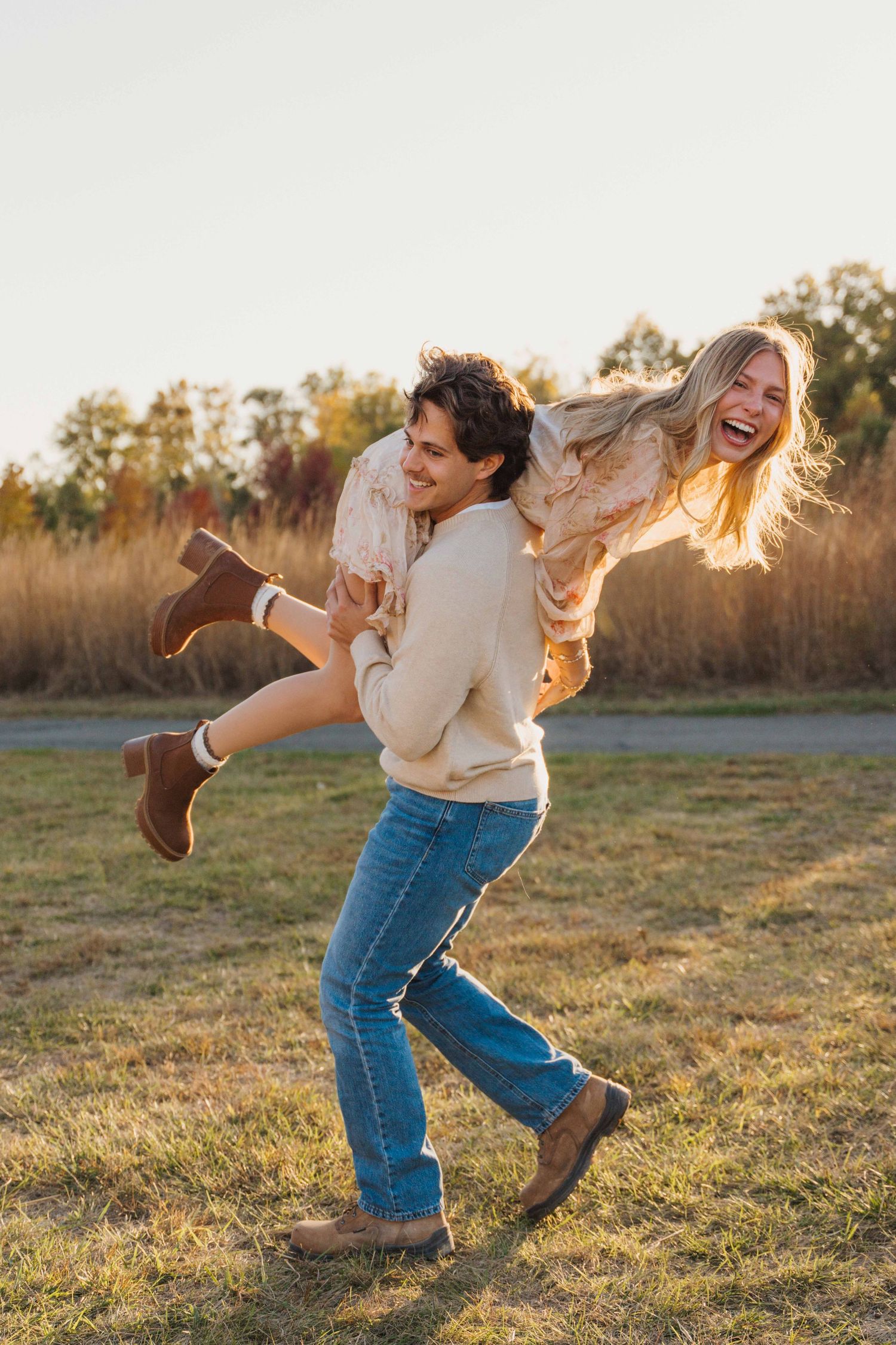 Two people dance playfully in a grassy field at golden hour, creating a joyful sequence of spinning movements.