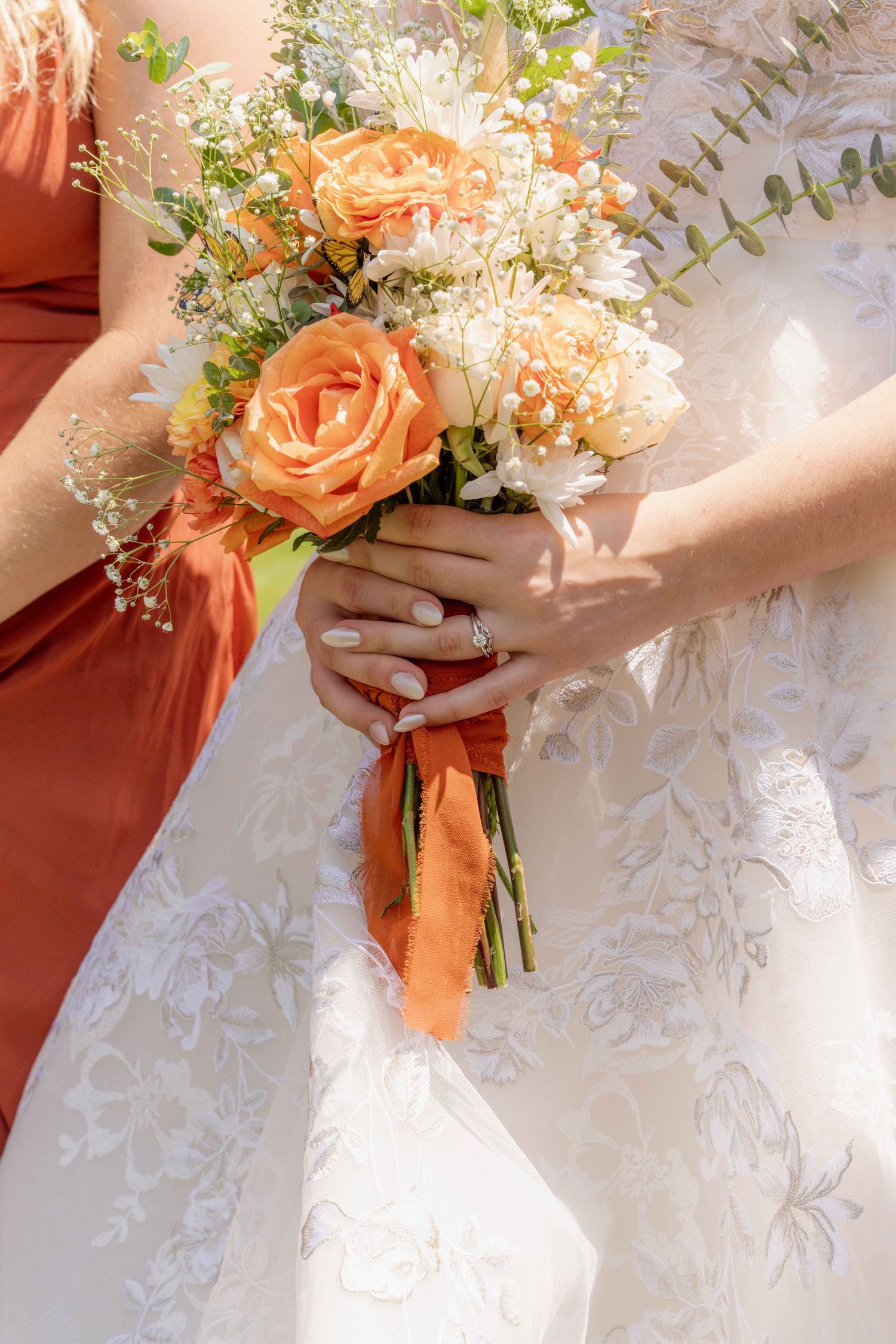 Peach roses and white floral wedding bouquet held against a delicate lace wedding dress in multiple detail shots.