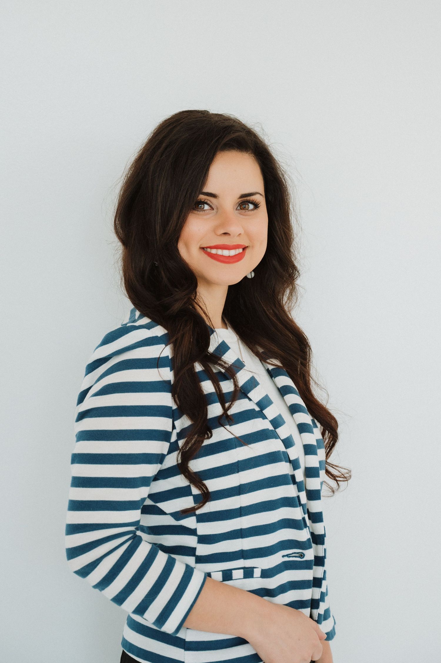 A smiling brunette woman wearing a blue and white striped jacket is ready to help you sign up for a CPO certification course.