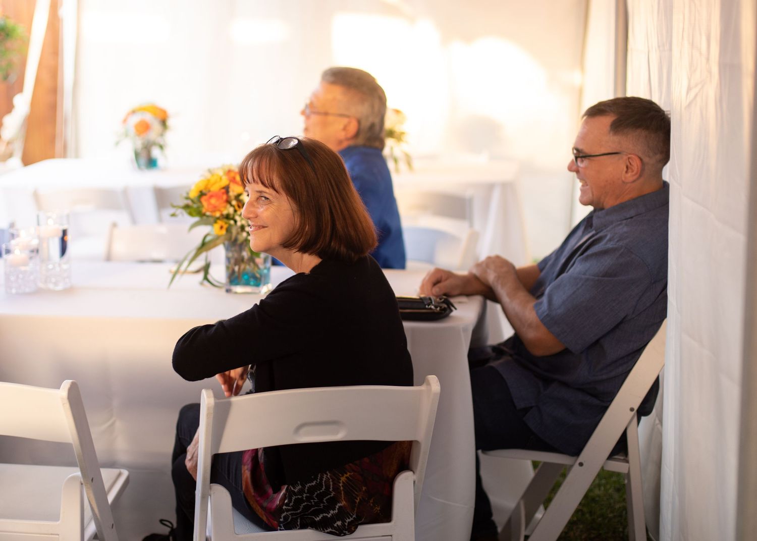 Wedding guests seated at tables during an indoor reception.