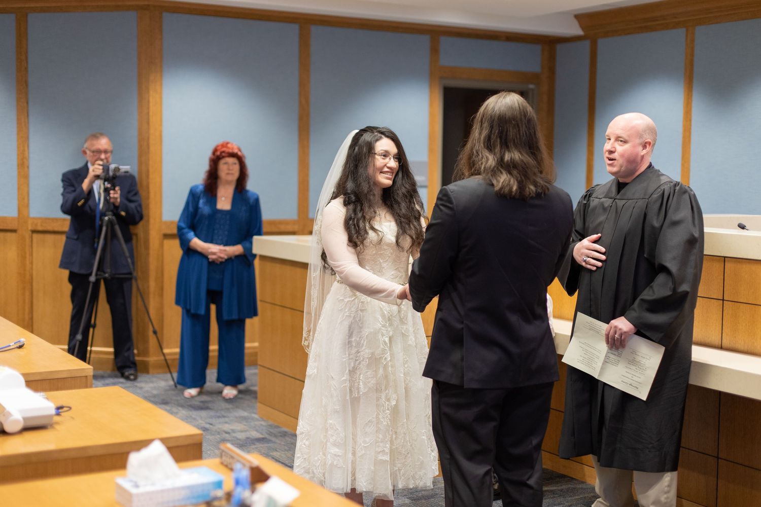 Small courthouse wedding ceremony with guests witnessing the proceedings.