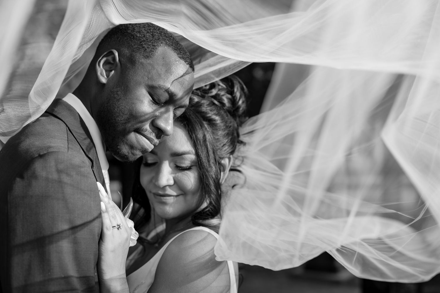 A tender moment between a newlywed couple under flowing white veils. Romantic Texas wedding photography by Gernelle Nelson