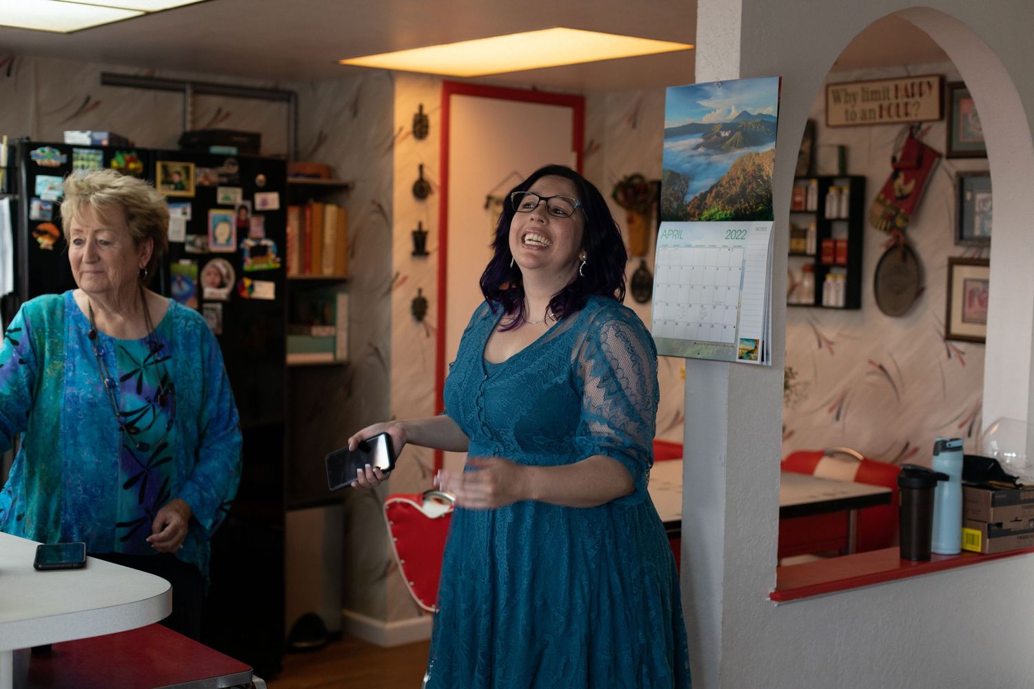 People enjoying a gathering in a casual indoor space with decorative wall art.