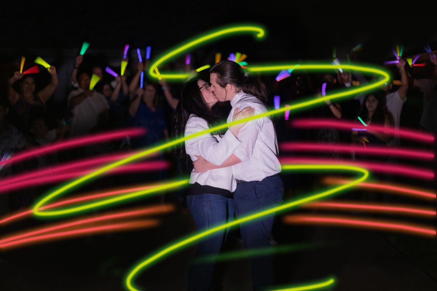 Wedding dance scene with vibrant neon light trails swirling around the dancing couple.