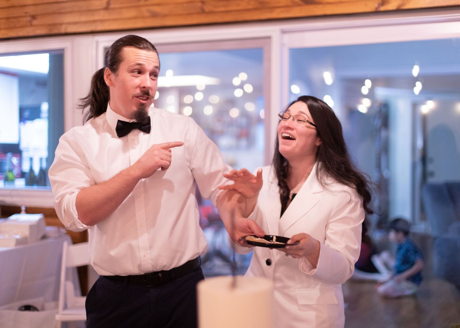 Two people enjoying desserts and sharing a laugh at a formal event.