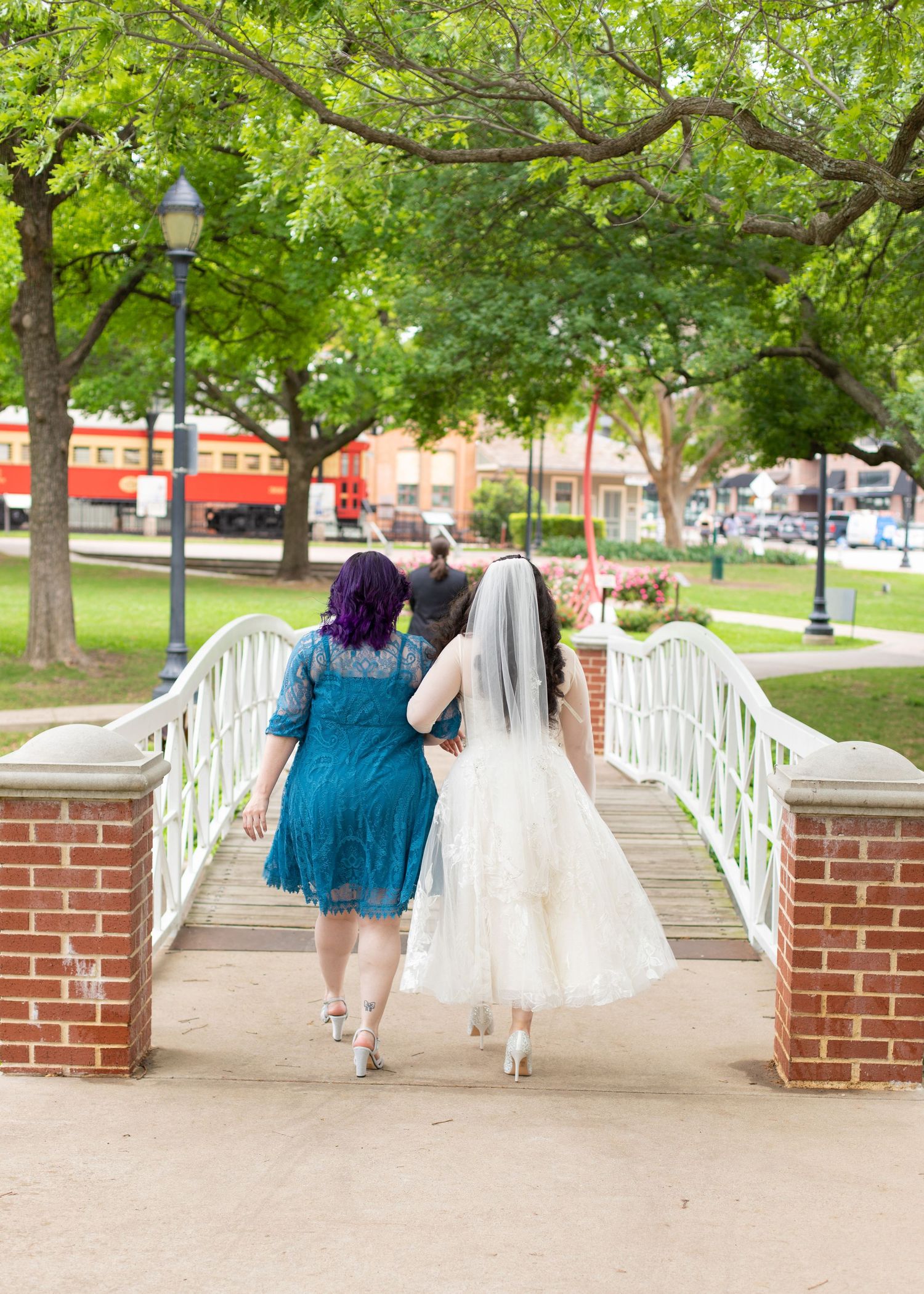 A formal wedding photo on a white bridge with someone in black tuxedo and someone in white dress.