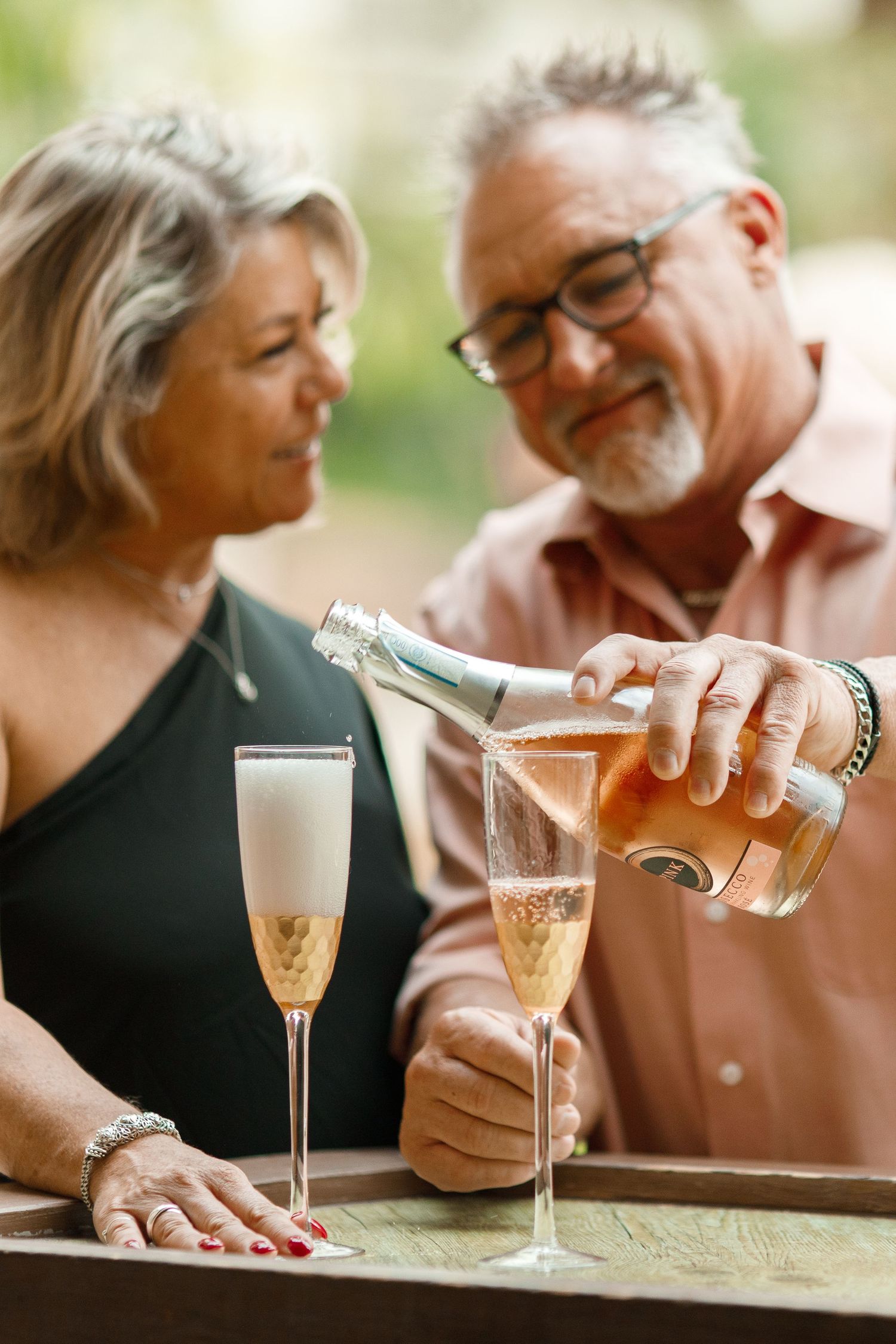 Couple enjoying champagne together outdoors in intimate setting.