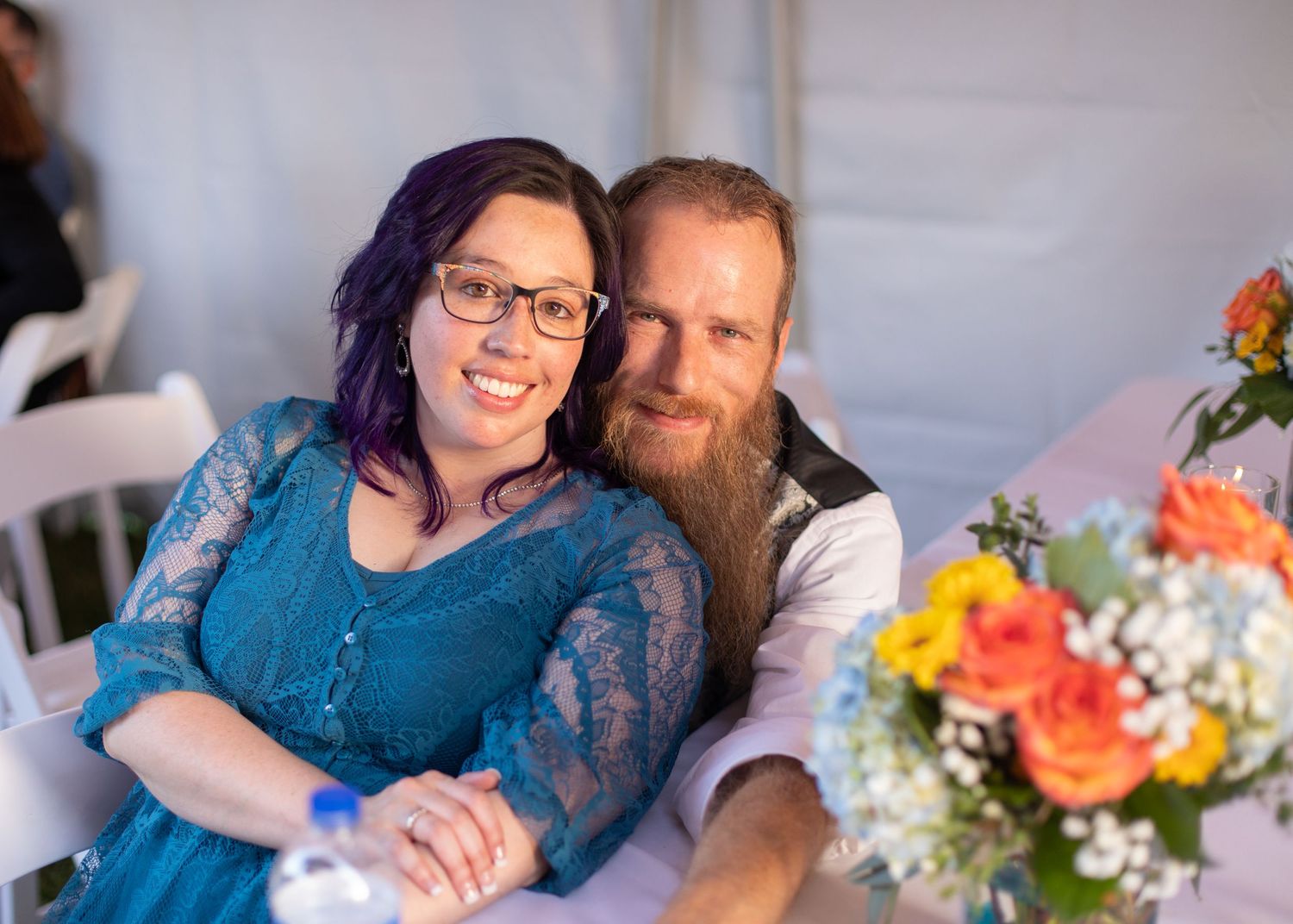A couple shares an intimate moment at a wedding reception.