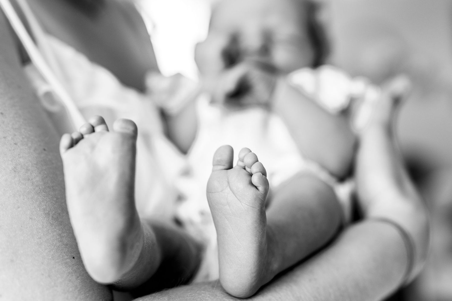 Close-up black and white photo of tiny newborn baby feet.