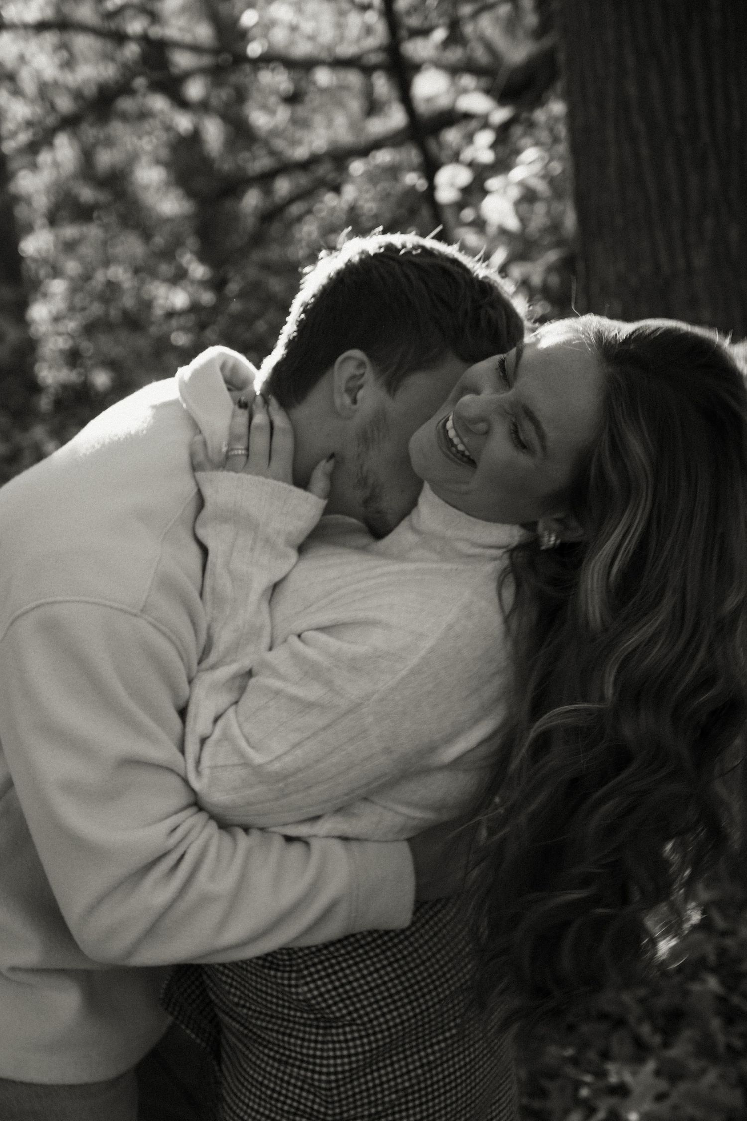 An intimate black and white sequence showing a couple's tender moments in a forest setting.