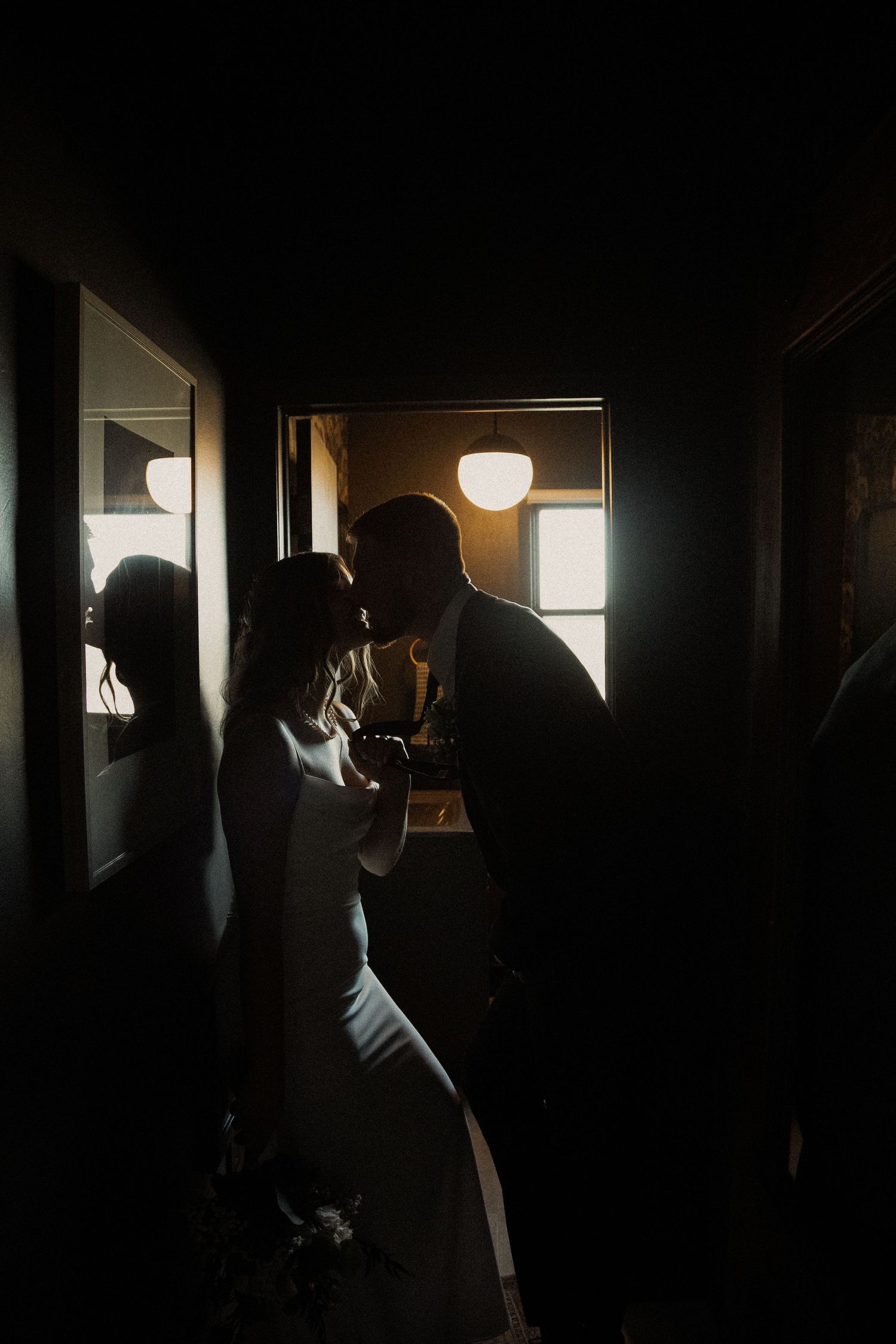 Silhouettes in a dark interior space with window light creating contrast.