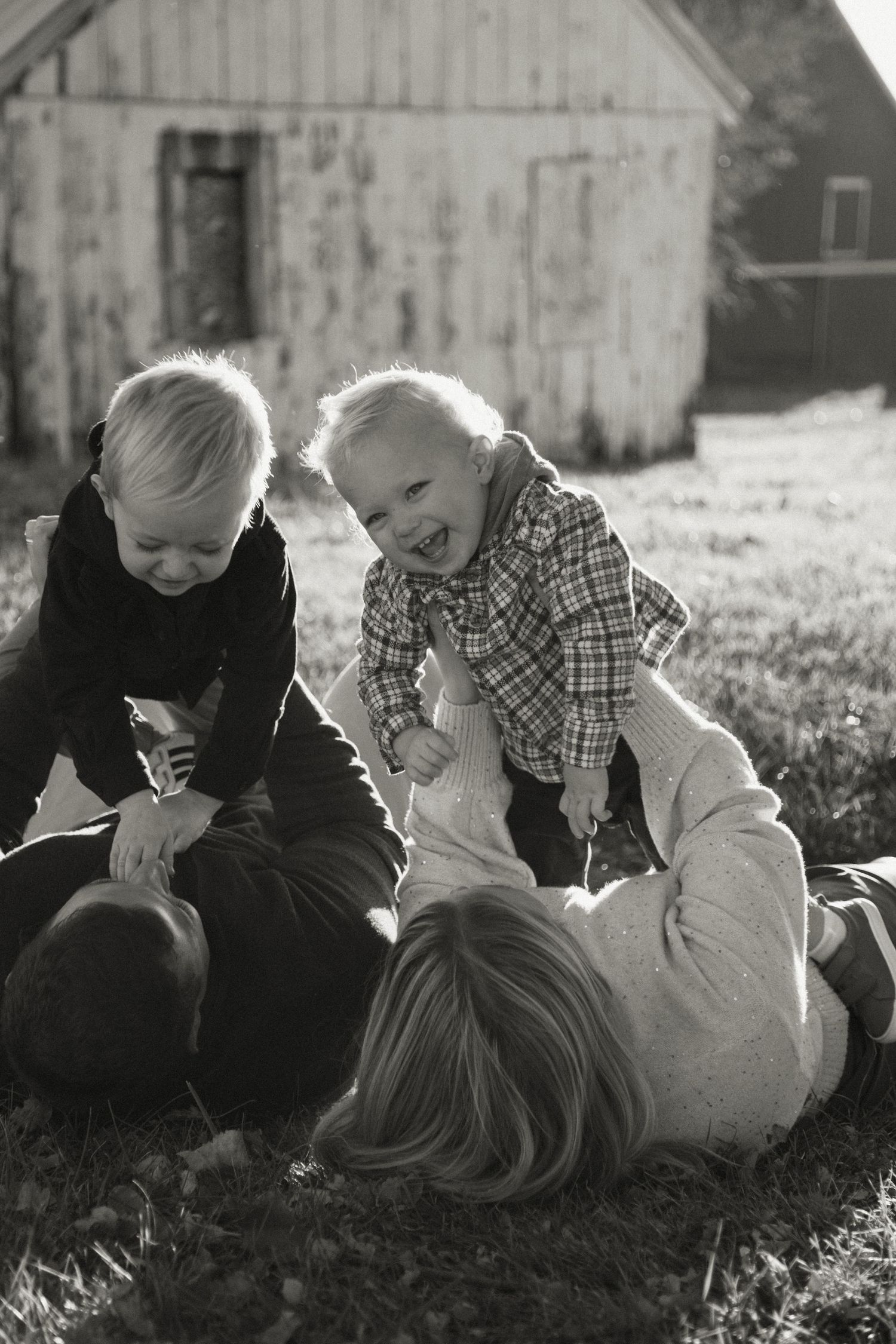 Joyful laughter and bonding time shared on the lawn in black and white photography.