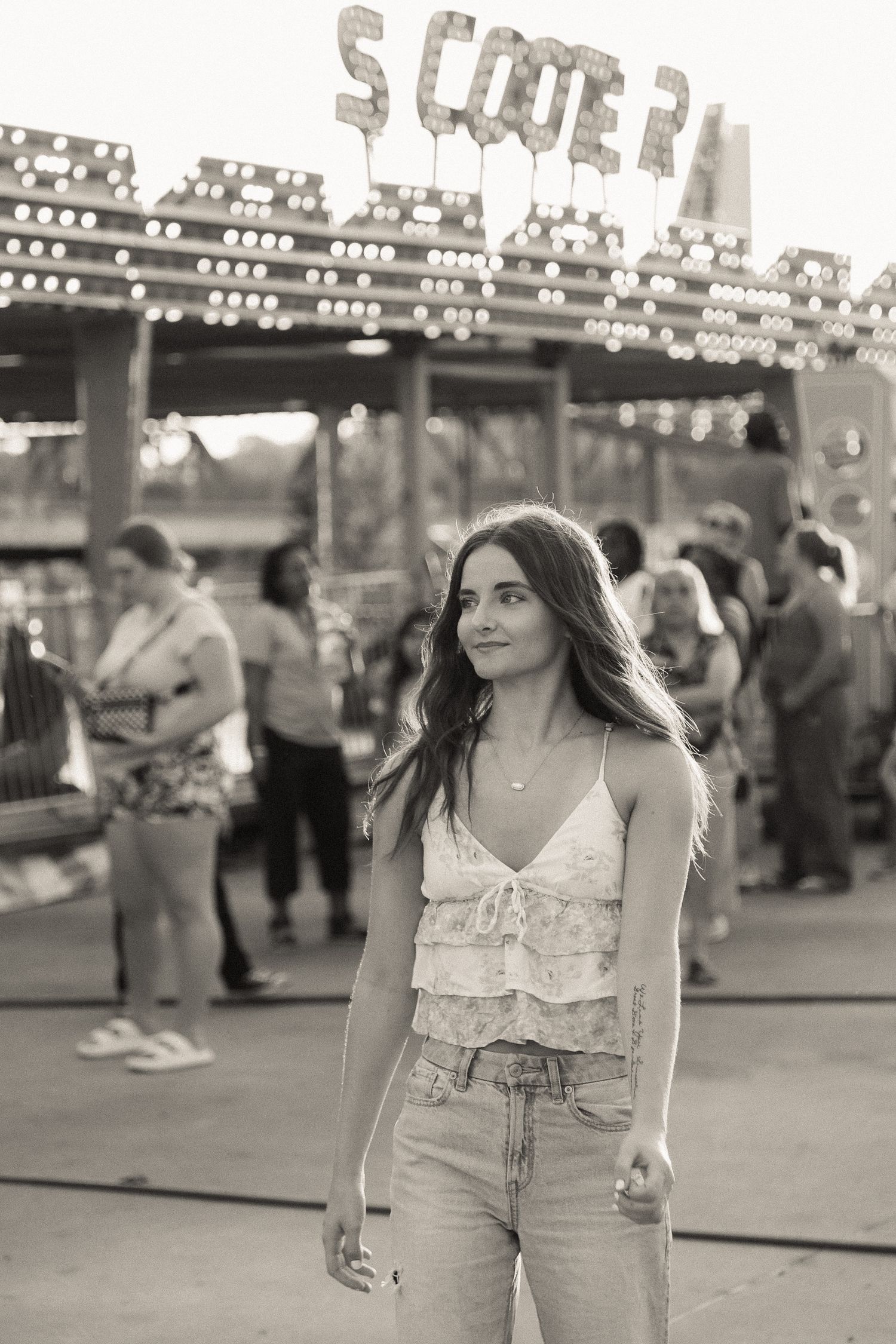 A summer carnival scene with string lights and a person in casual attire.
