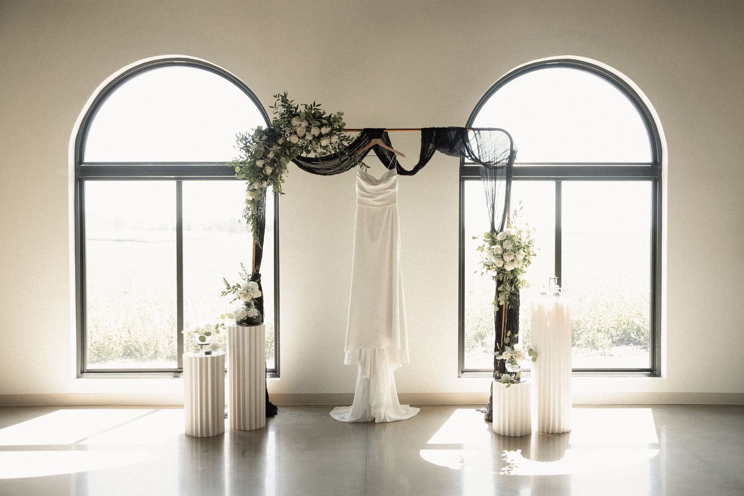 Elegant arched windows in a bright white room with minimal decor.