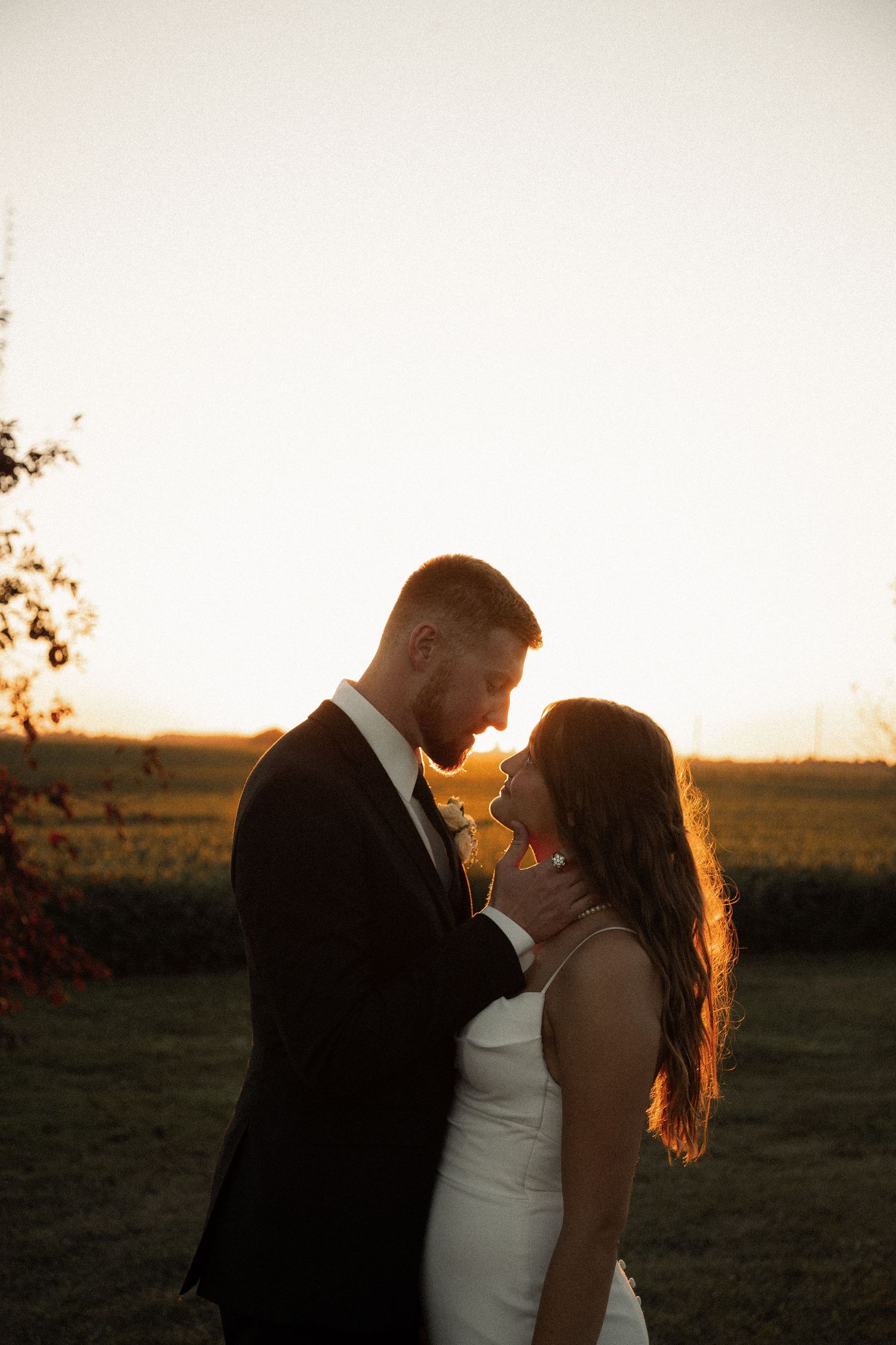 An intimate wedding portrait captured during golden hour with warm sunset lighting.