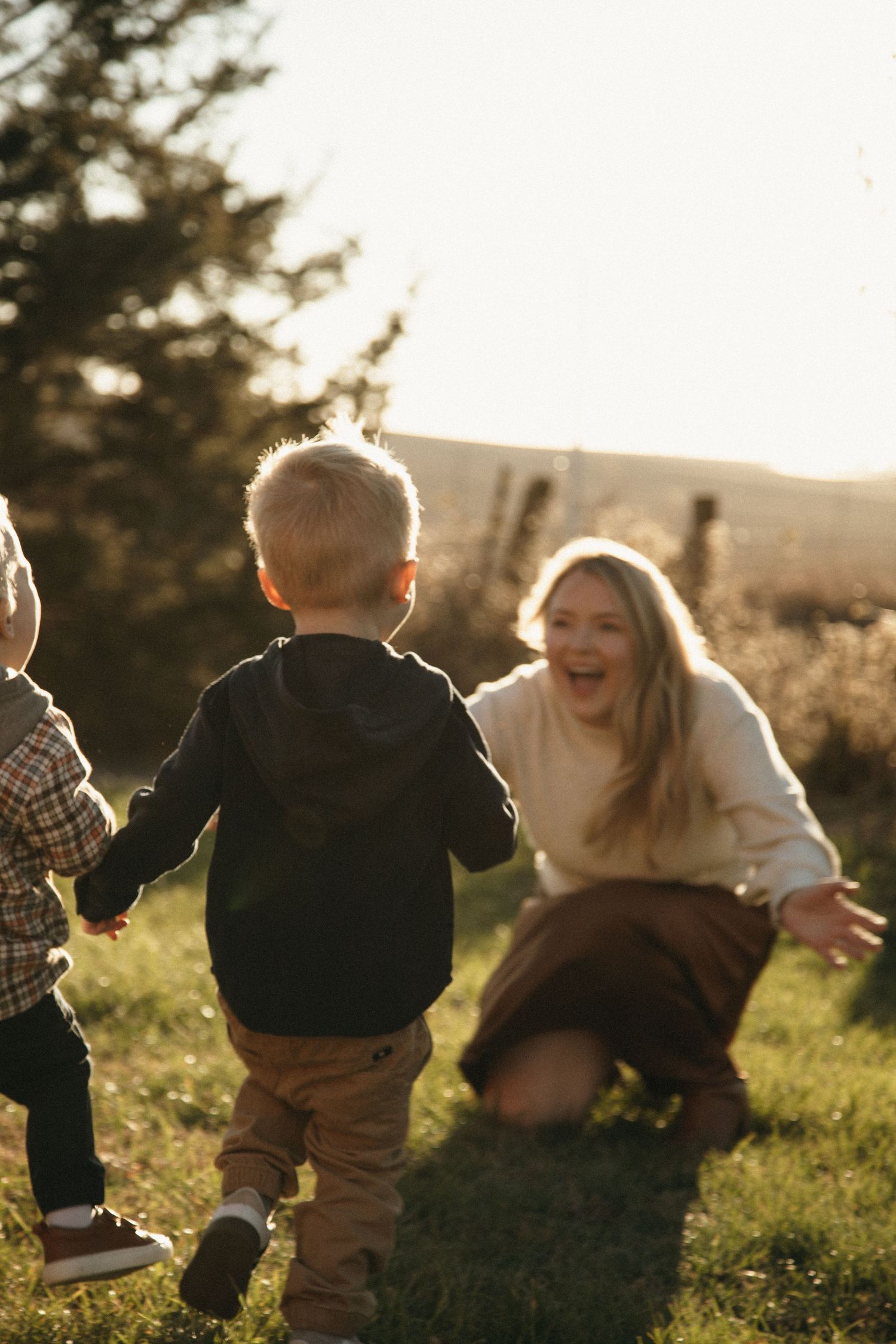Candid family playtime captured in motion during golden sunset.