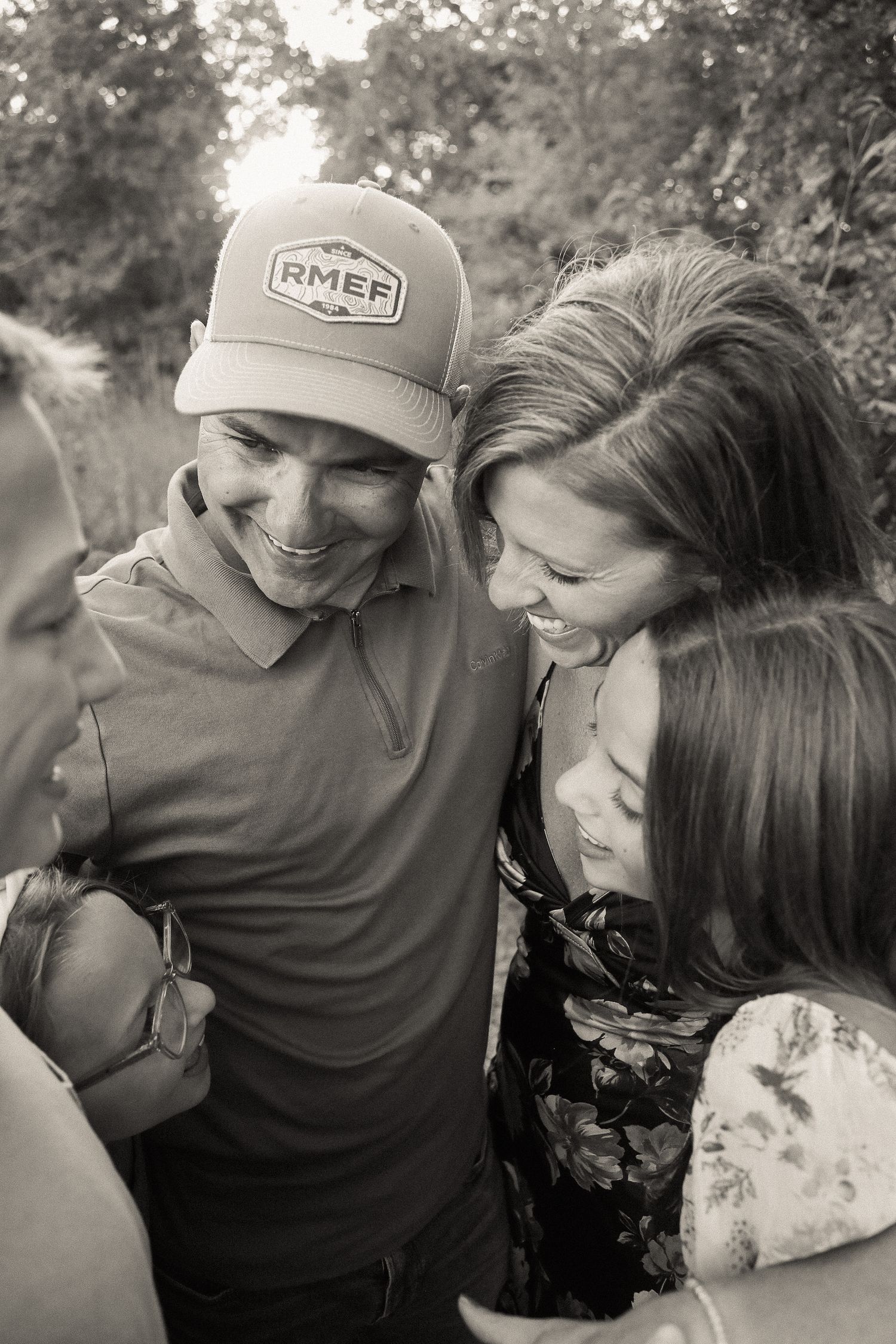 Black and white outdoor portrait of a couple sharing joyful laughter together.