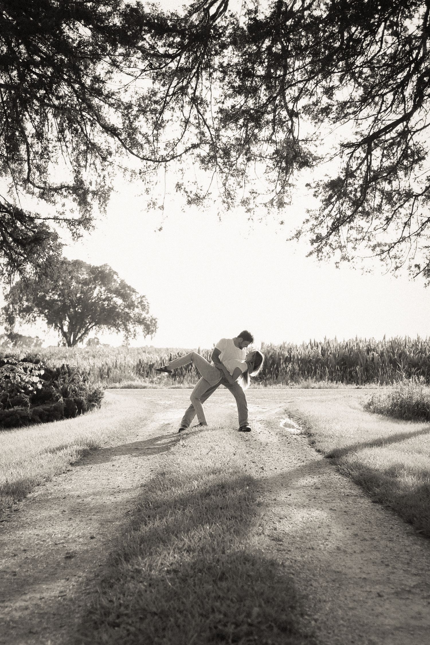 Artistic black and white sequence of playful poses on a grassy hill.