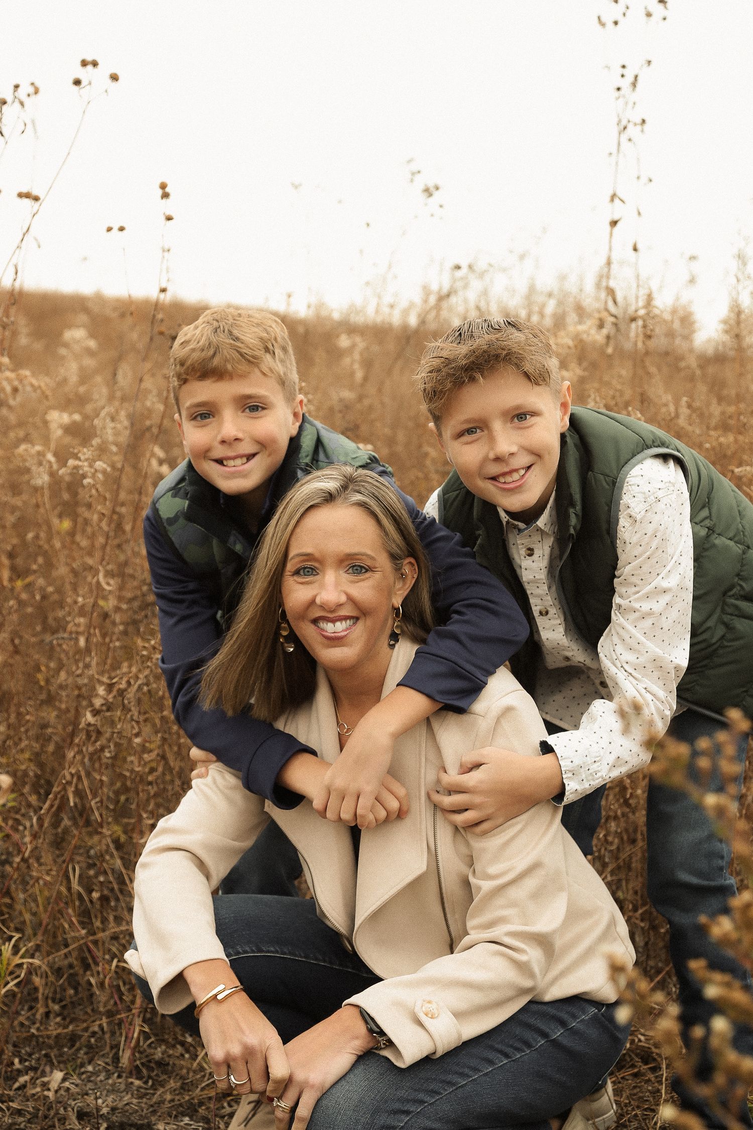 Candid family portrait showing joyful expressions in a rustic outdoor setting.