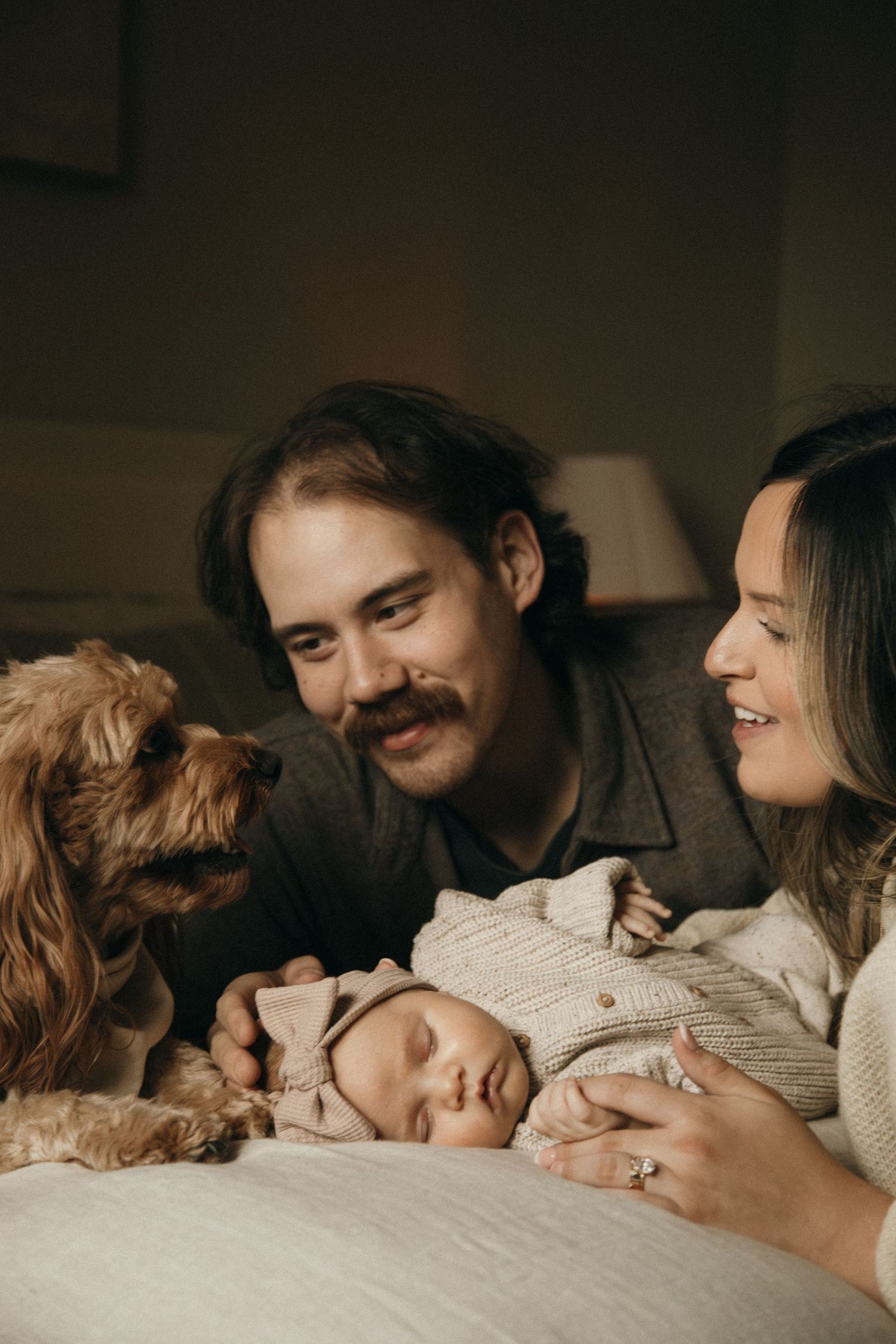 Intimate family moment captured in warm, moody indoor lighting.