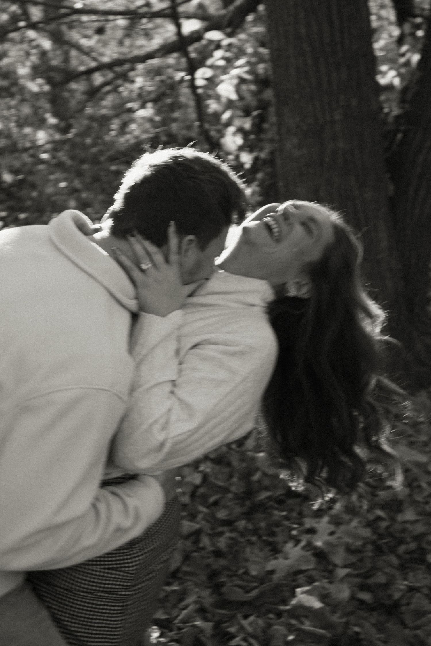 A black and white sequence showing two people embracing in a wooded setting.